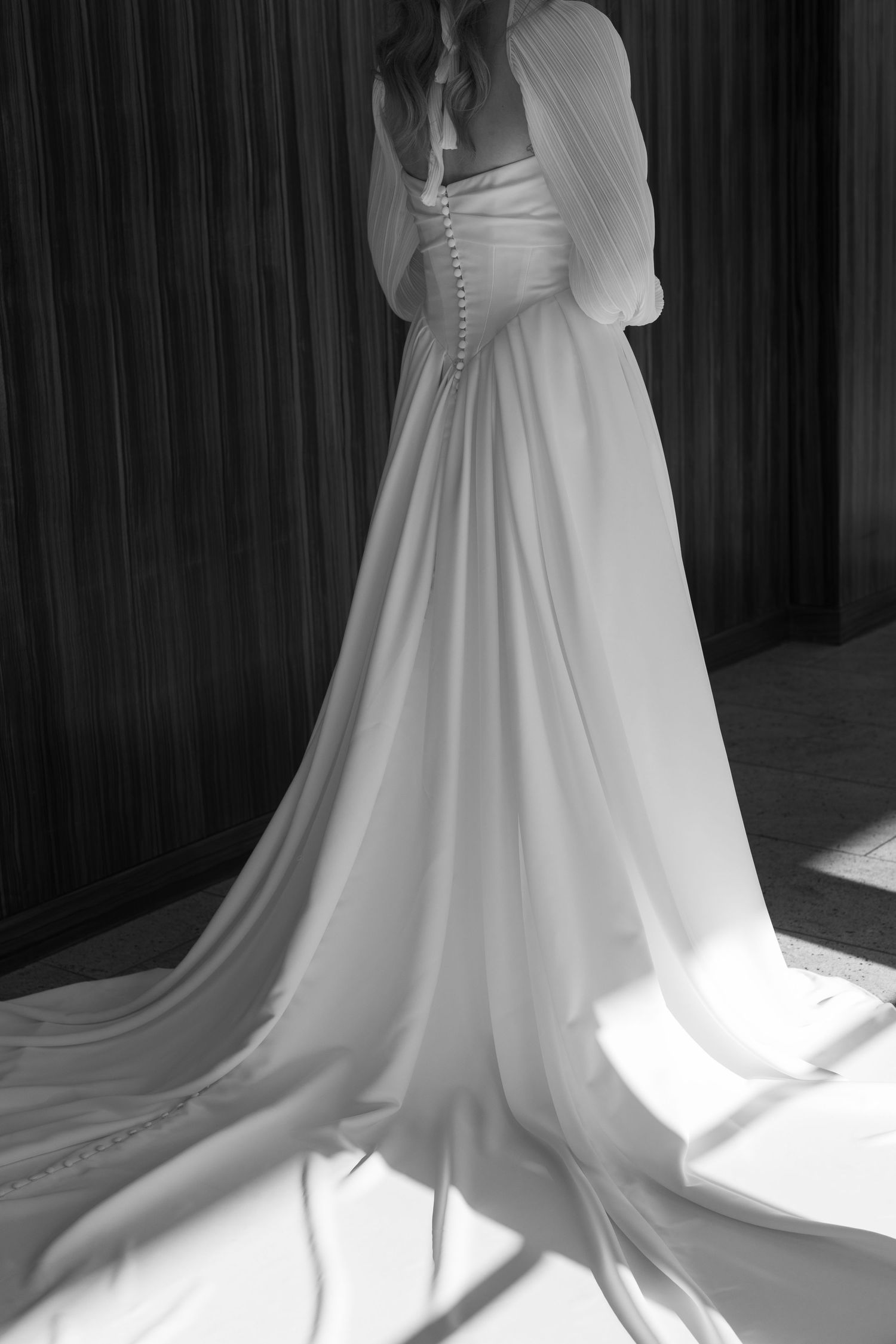 Dramatic black and white photos of a wedding dress train flowing across the floor.