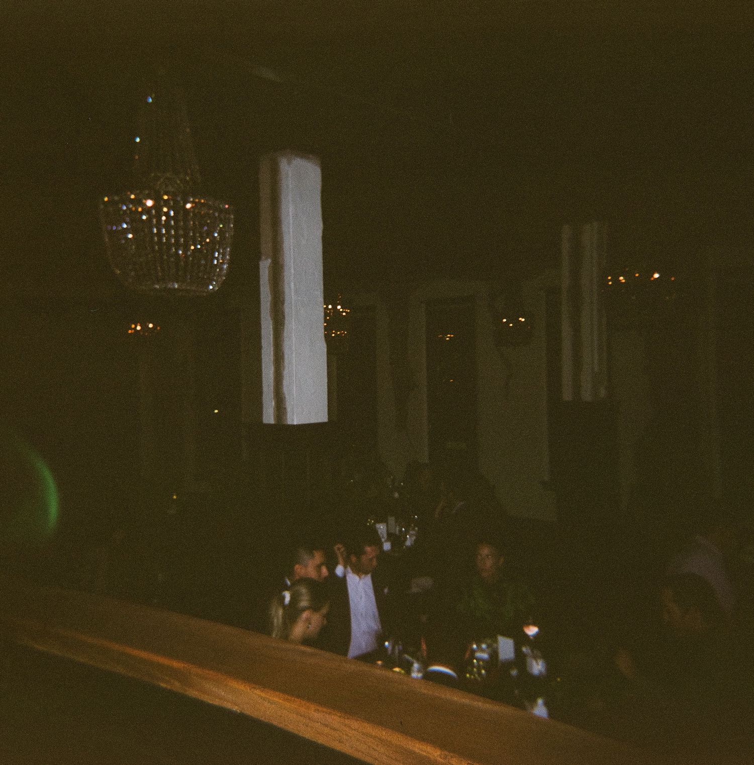 Dimly lit event space with chandeliers creating ambient lighting for evening gathering.