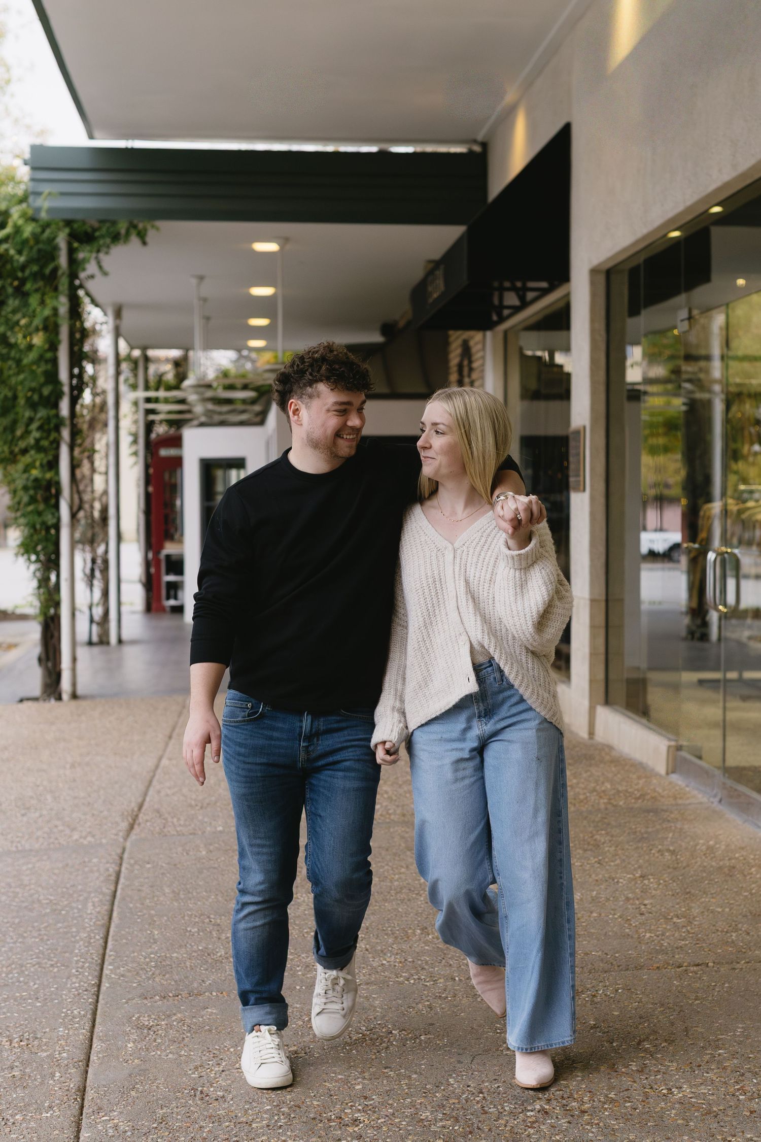 A couple walking together under a covered walkway.