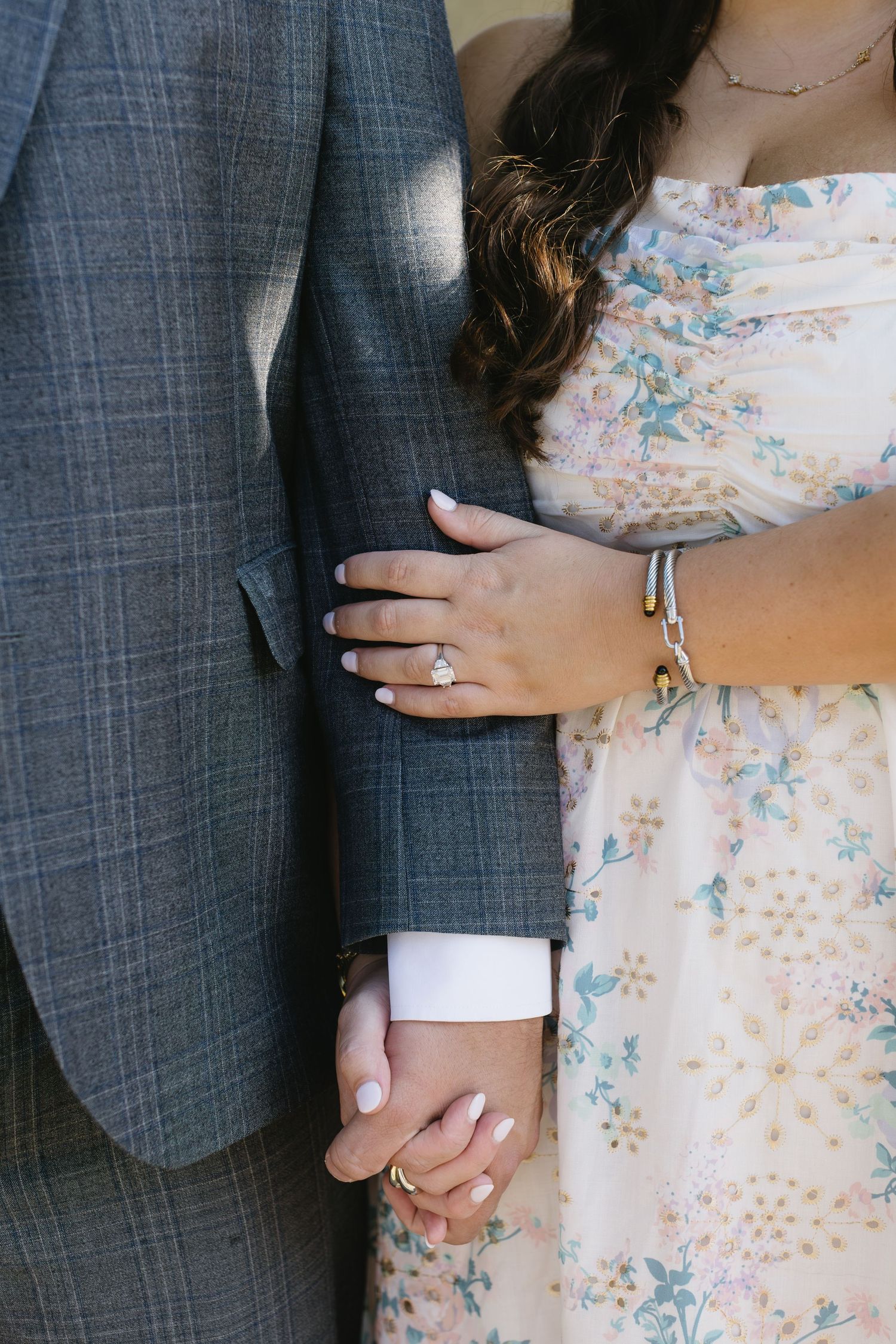 Close-up shots of hands and rings showing romantic engagement or wedding moments against a grey suit background.