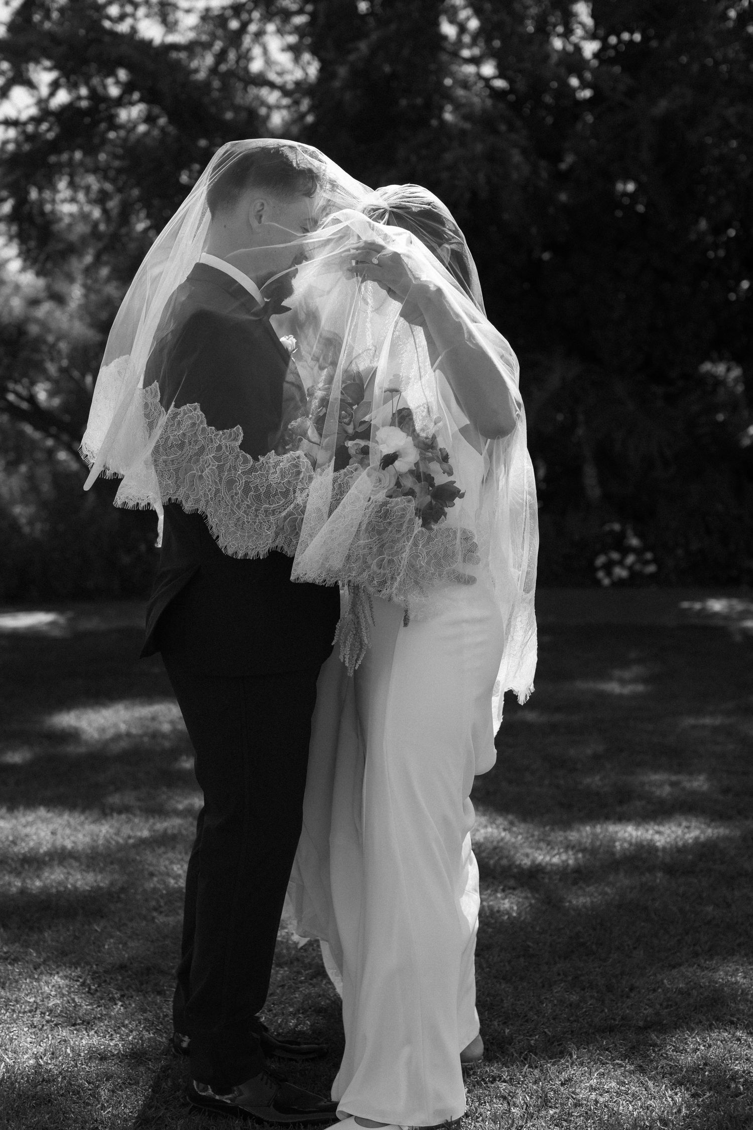 A series of romantic black and white wedding photos showing a couple in a veil and formal attire outdoors.
