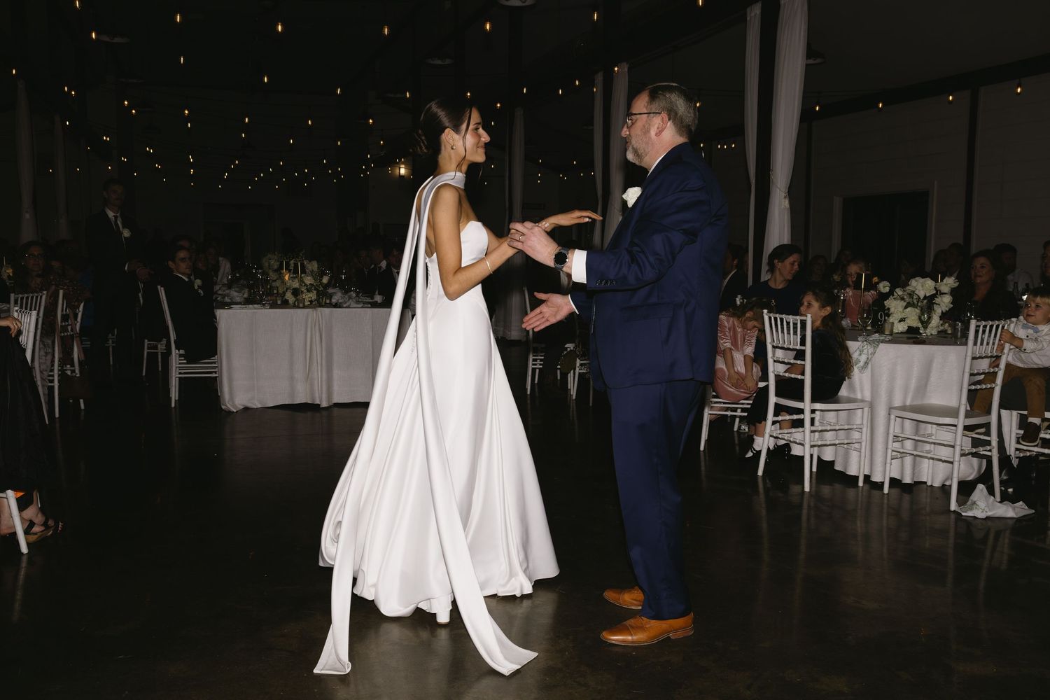 Wedding reception dance floor with string lights creating a magical evening atmosphere.
