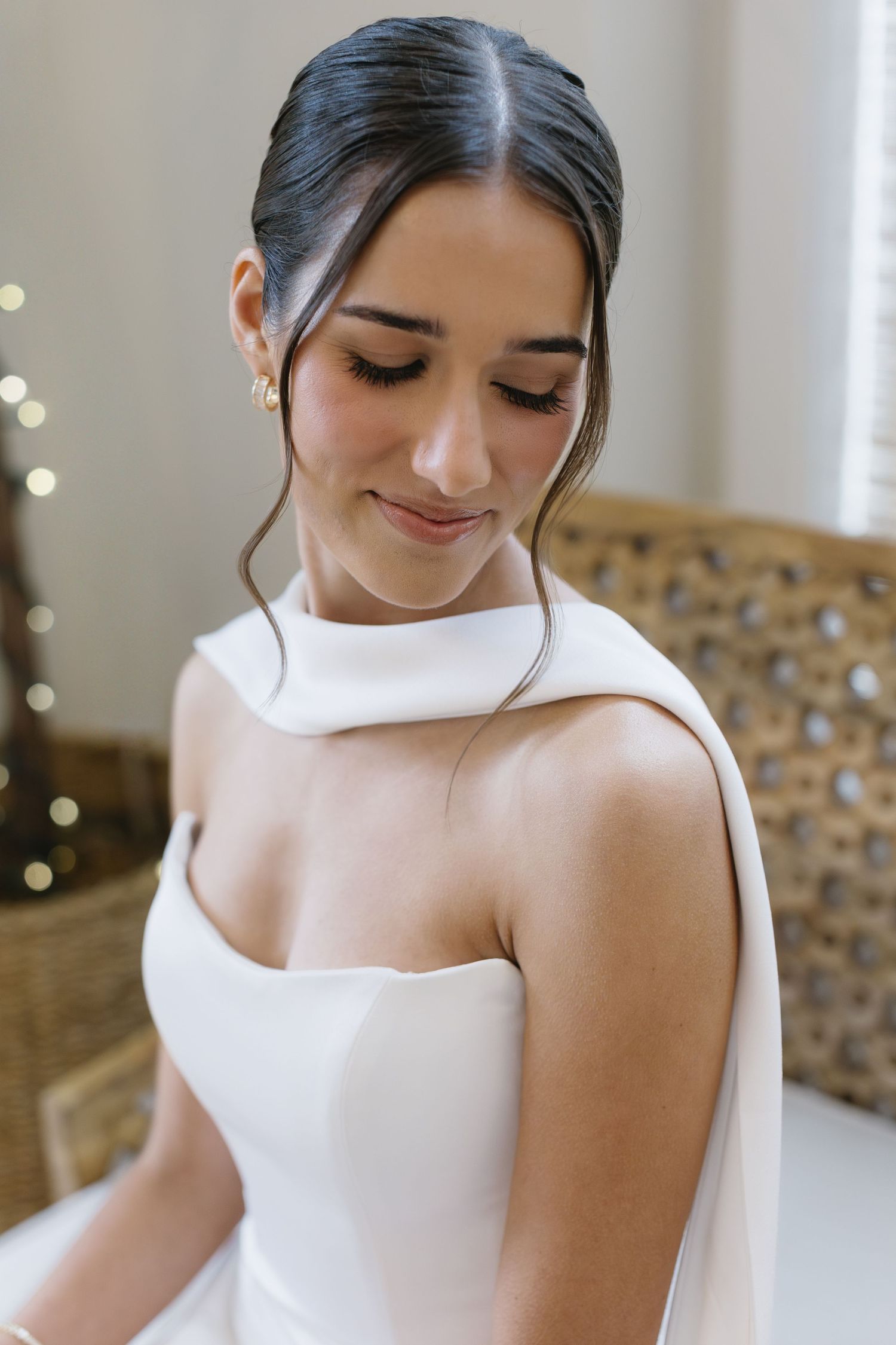 Close-up details of an elegant white wedding dress bodice with a modern asymmetrical neckline.