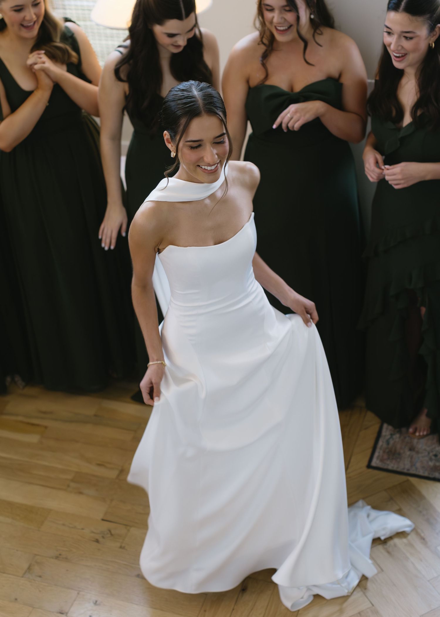 Joyful moments captured during a wedding dress fitting with bridesmaids in black dresses.