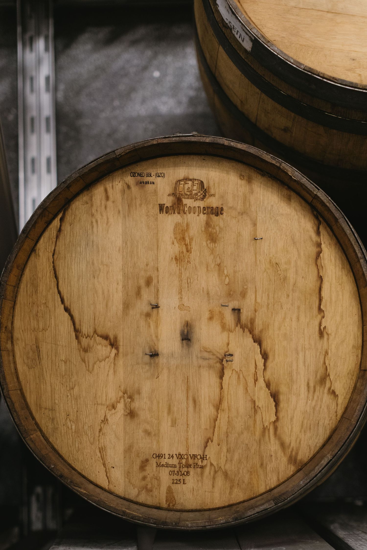 Aged wooden wine barrels stacked in a cellar showing natural wood grain patterns.