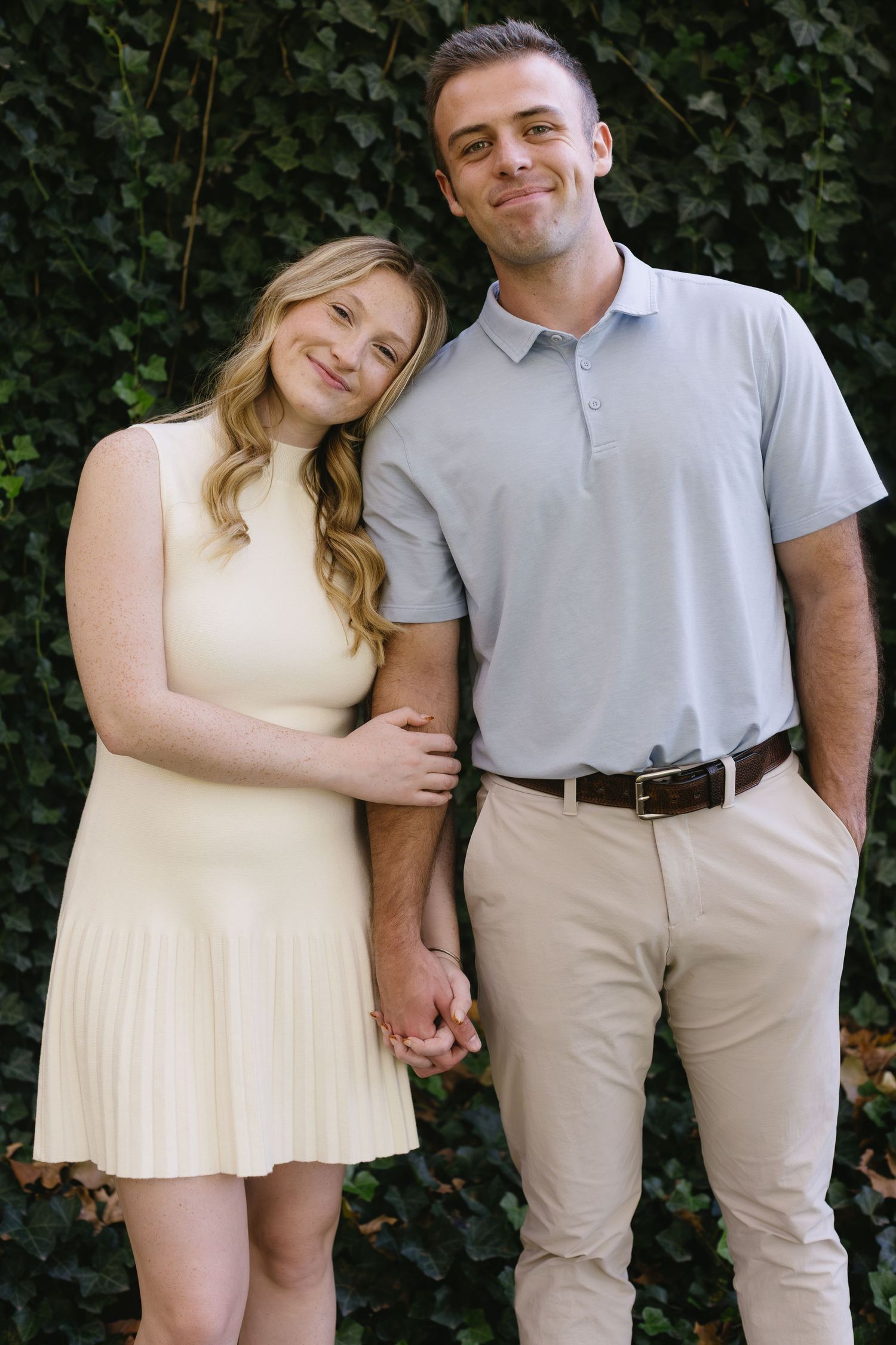 Couple in light summer attire posing against ivy-covered wall in progression of intimate poses.