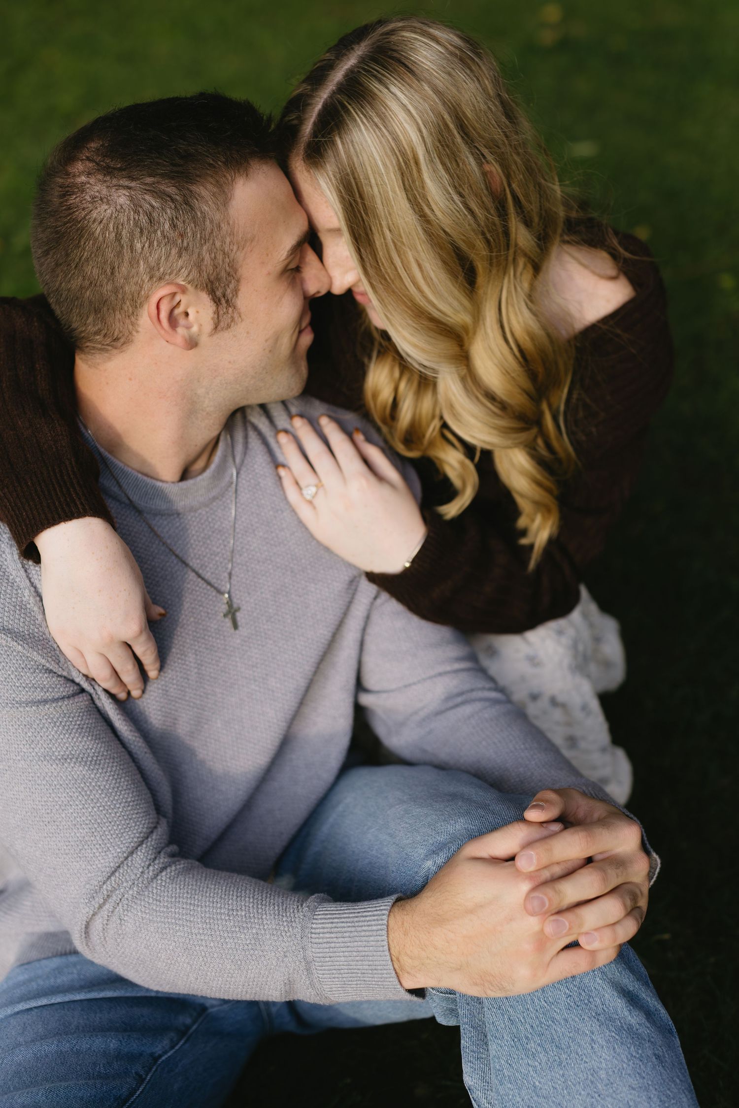 An intimate close-up of a couple sharing a tender moment outdoors.