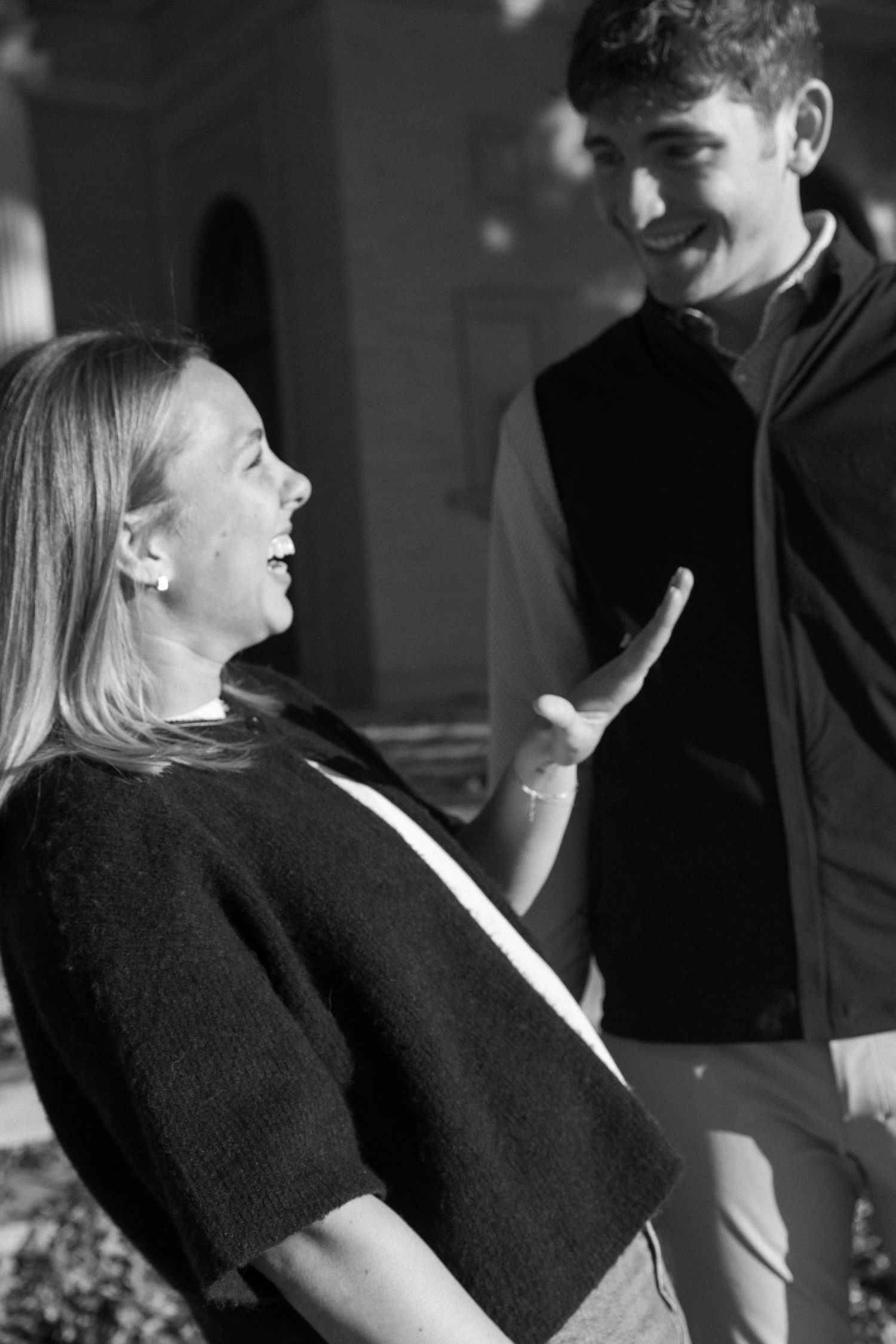 A couple sharing laughter in black and white photography.