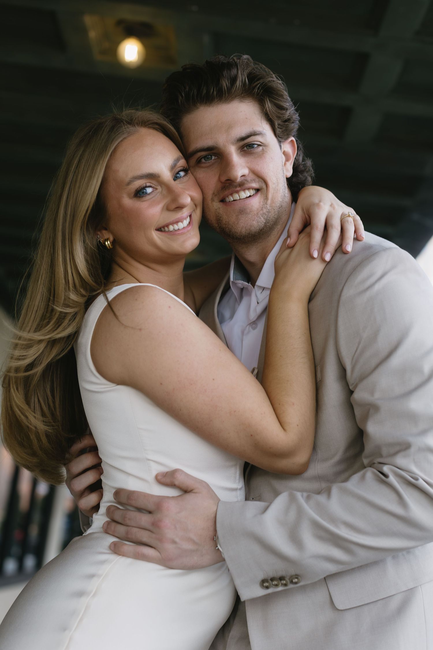 A romantic couple in white and beige outfits share intimate moments in a photo series.