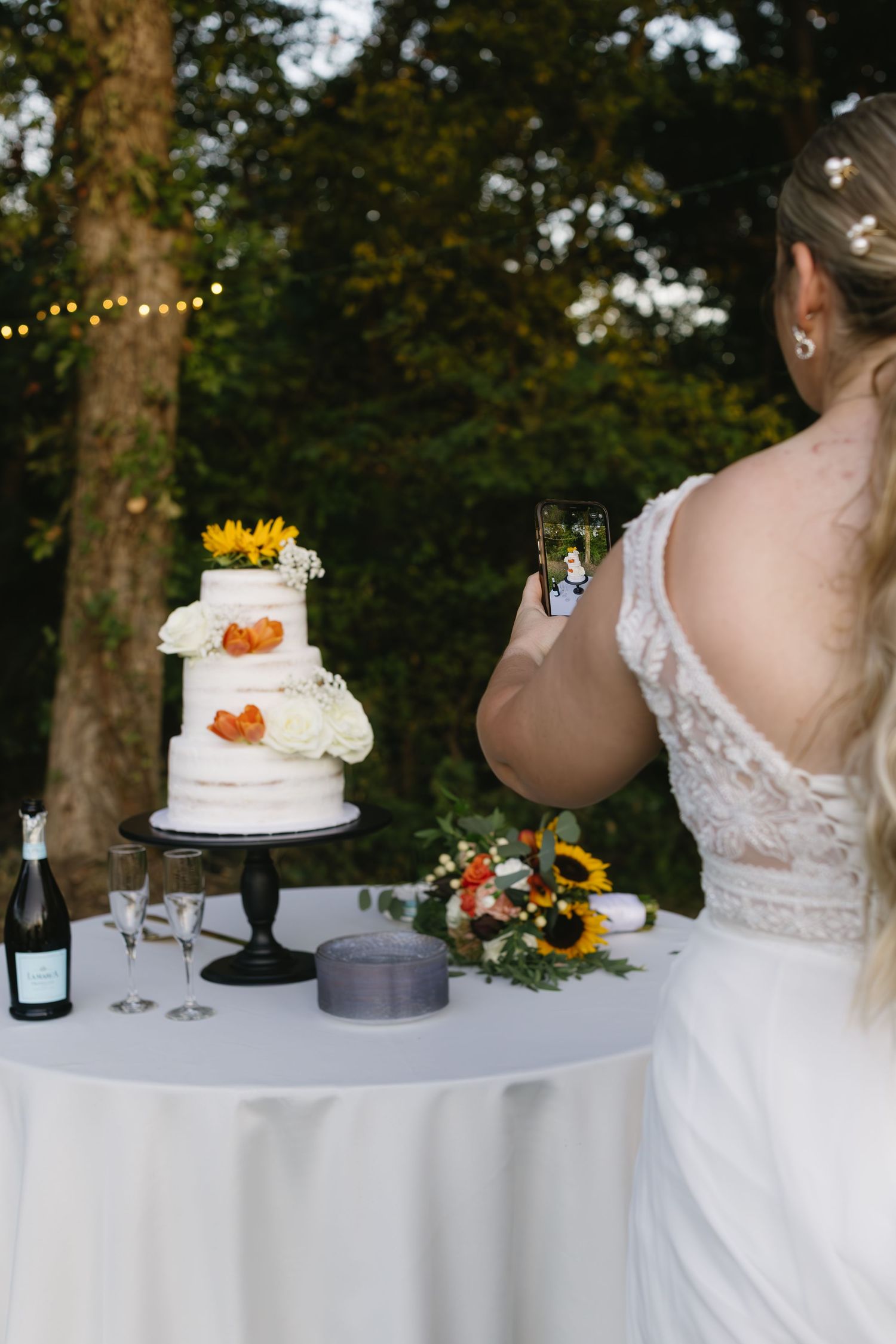 Wedding cake display table with floral decorations and white tablecloth.