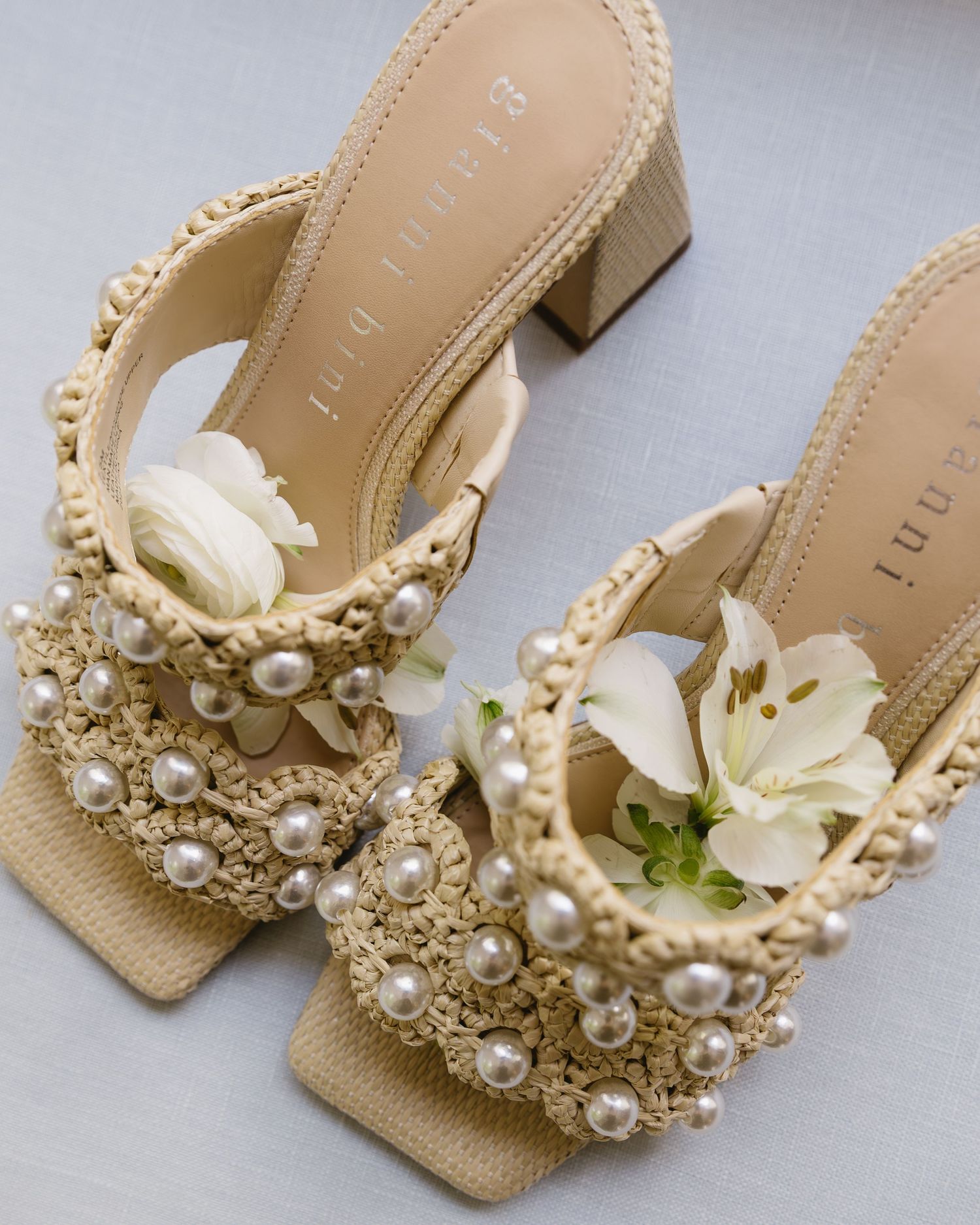 Elegant beige bridal shoes adorned with pearls and floral embellishments displayed at different angles.