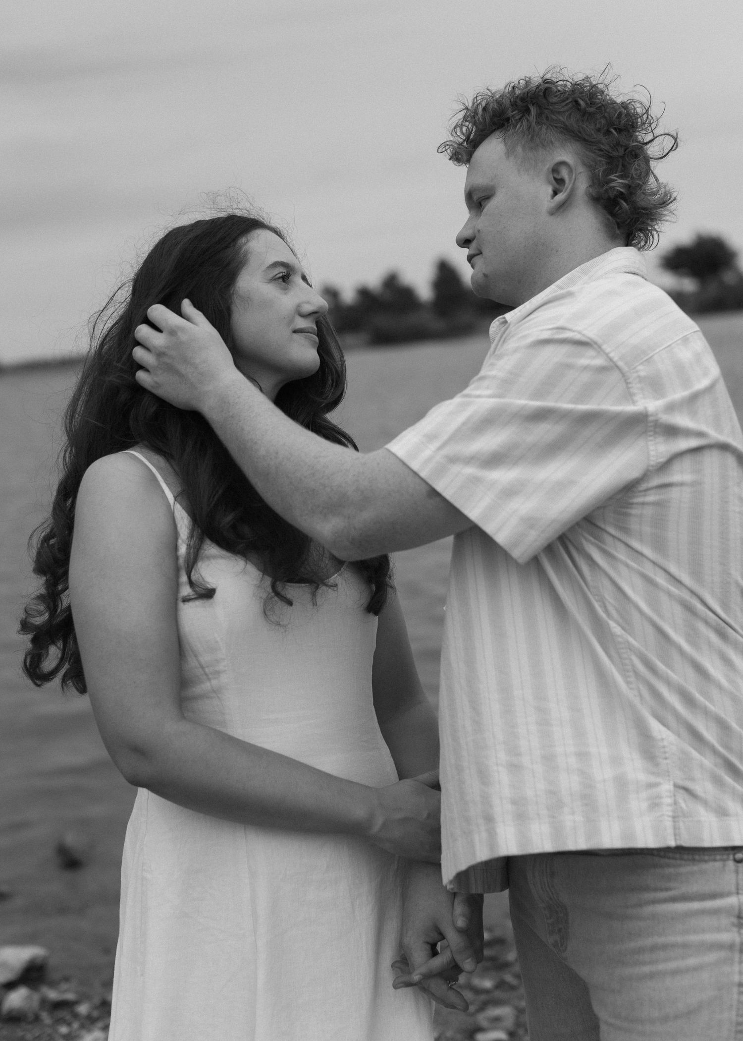 Black and white romantic photo sequence showing a couple sharing tender moments by the water.