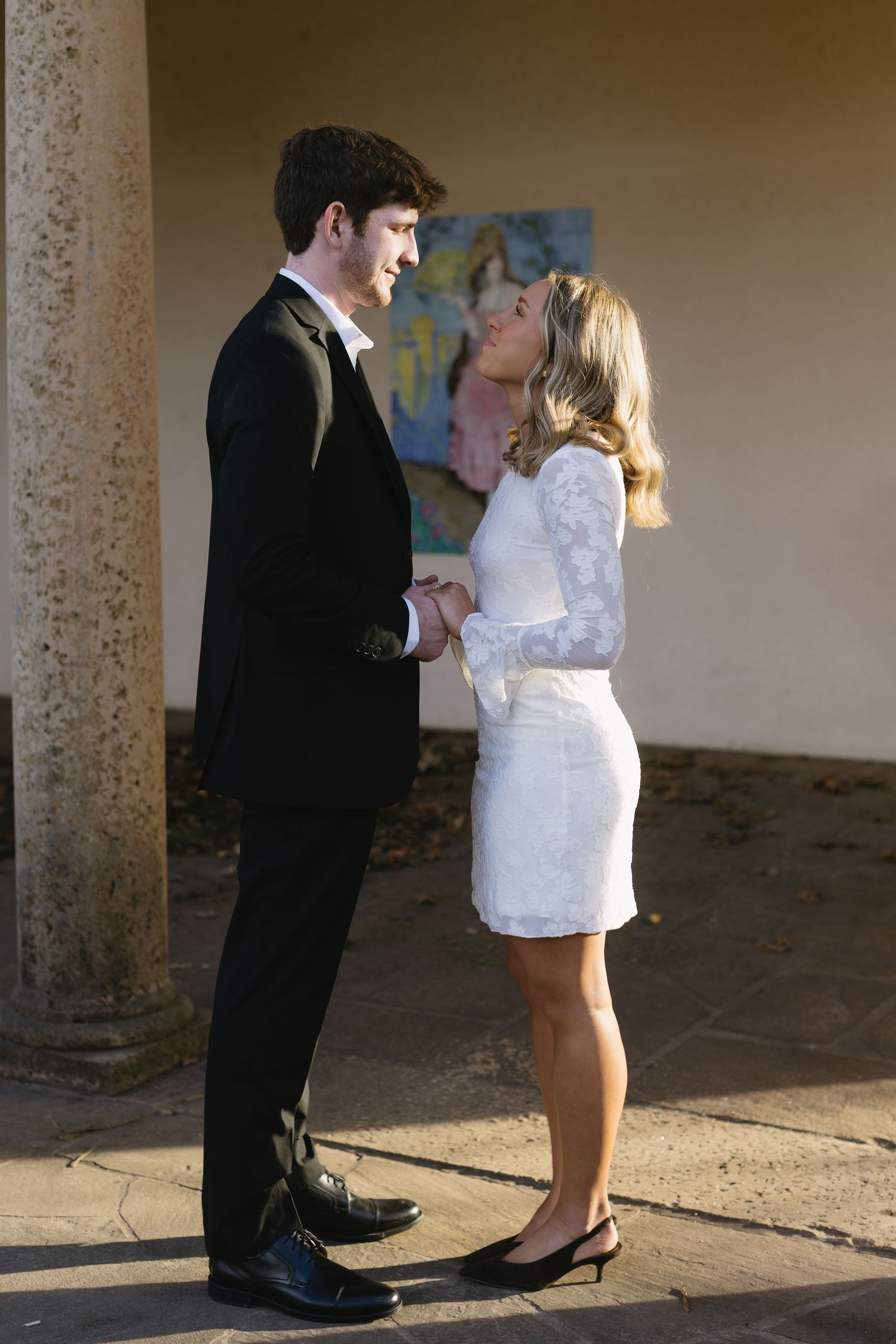 Wedding couple photographed from waist down showing dress details and formal shoes.