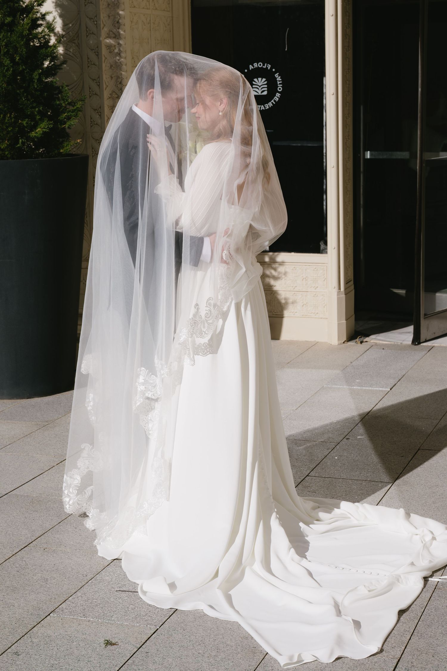Ethereal bridal portraits showing flowing white wedding dress and veil in natural sunlight.