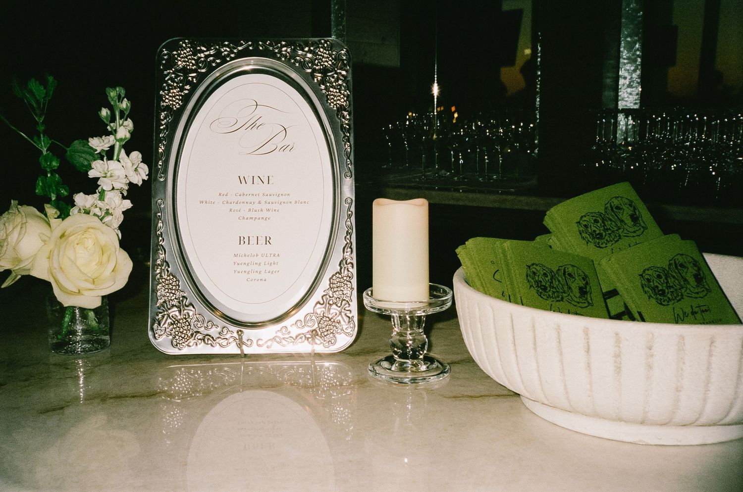 Wedding reception table decor with elegant white place settings and floral arrangements.