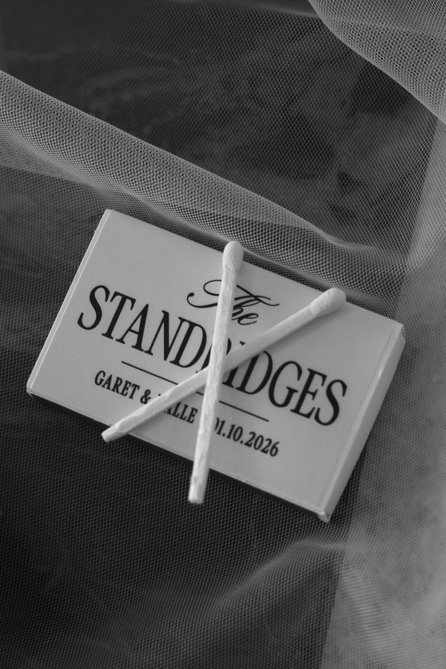 Black and white photograph showing name badges or place cards arranged in a row with dramatic lighting and smoke effects.