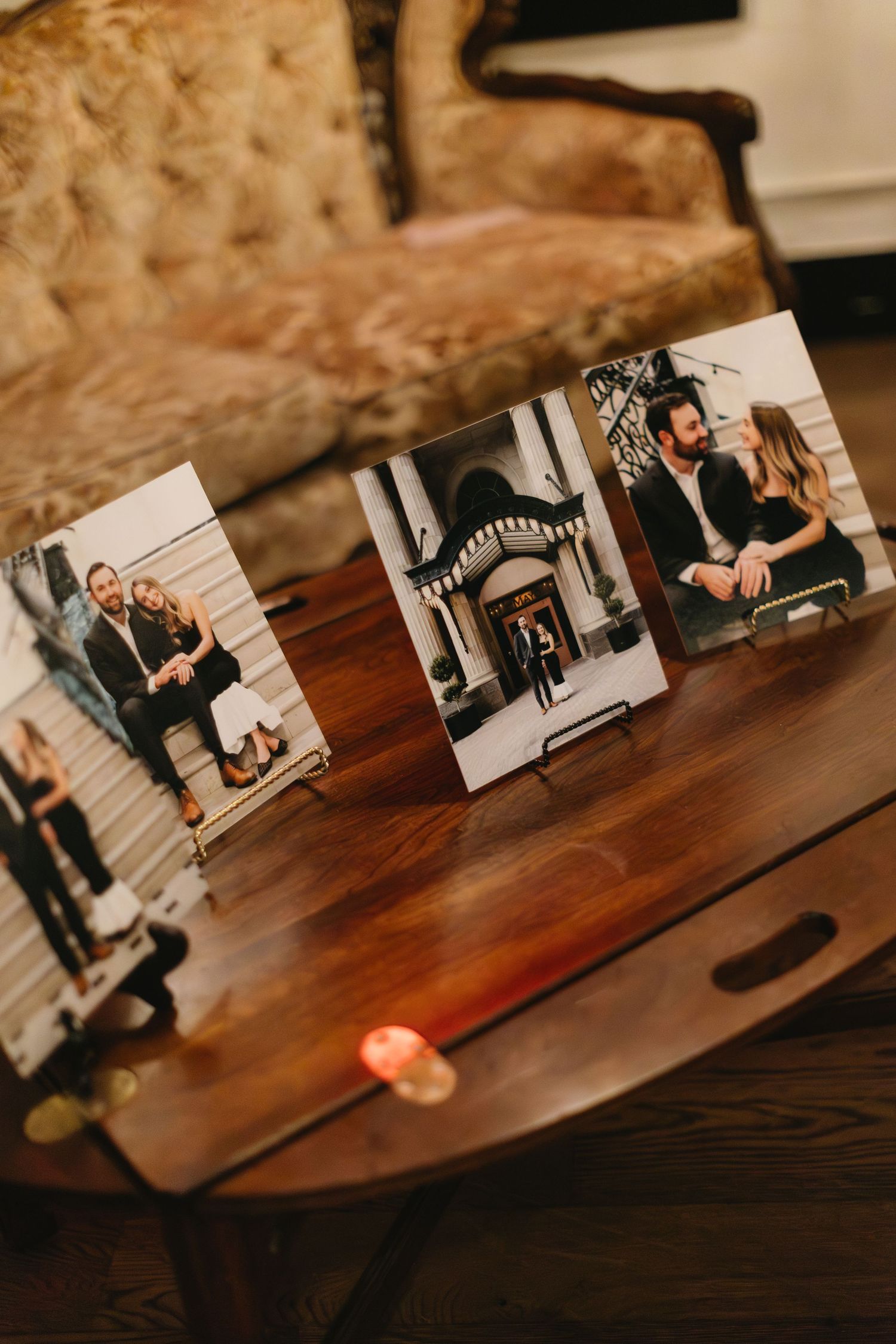 Black and white photographs arranged on a dark wooden table surface.