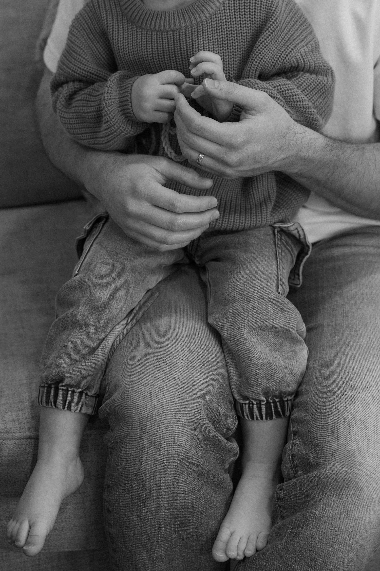 Close-up shots of someone in a gray sweater holding a small child on their lap.