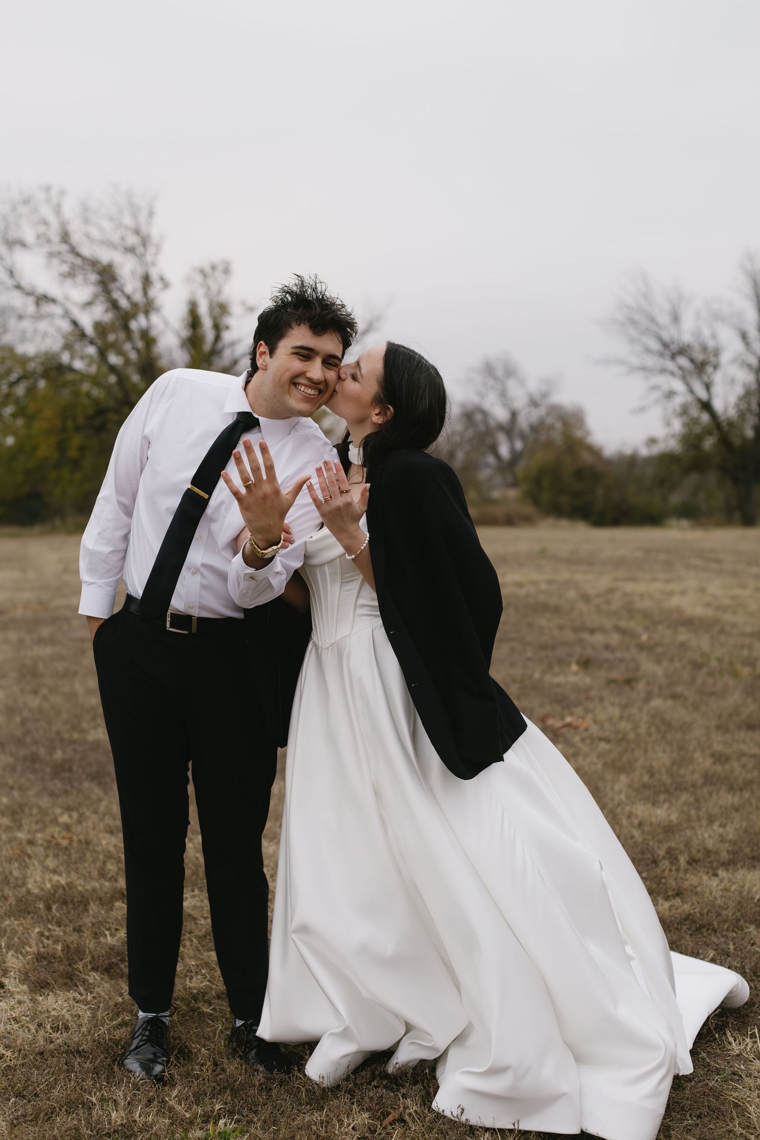 Candid wedding photos showing joyful moments between newlyweds in an outdoor field setting.