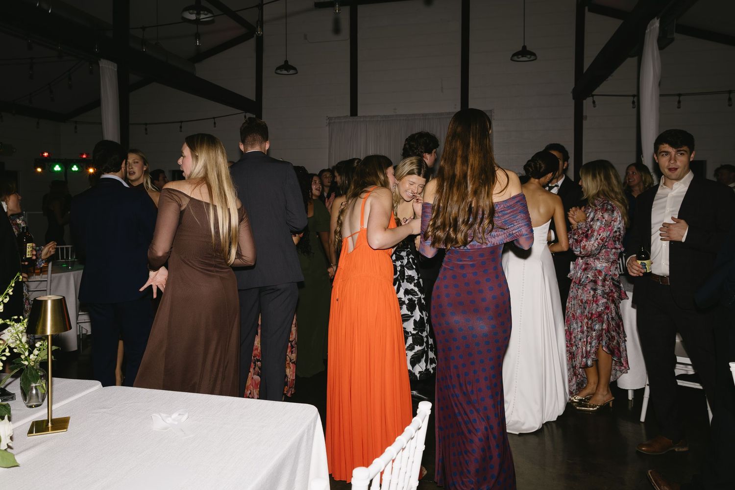 Wedding guests enjoying the dance floor at an evening reception celebration.