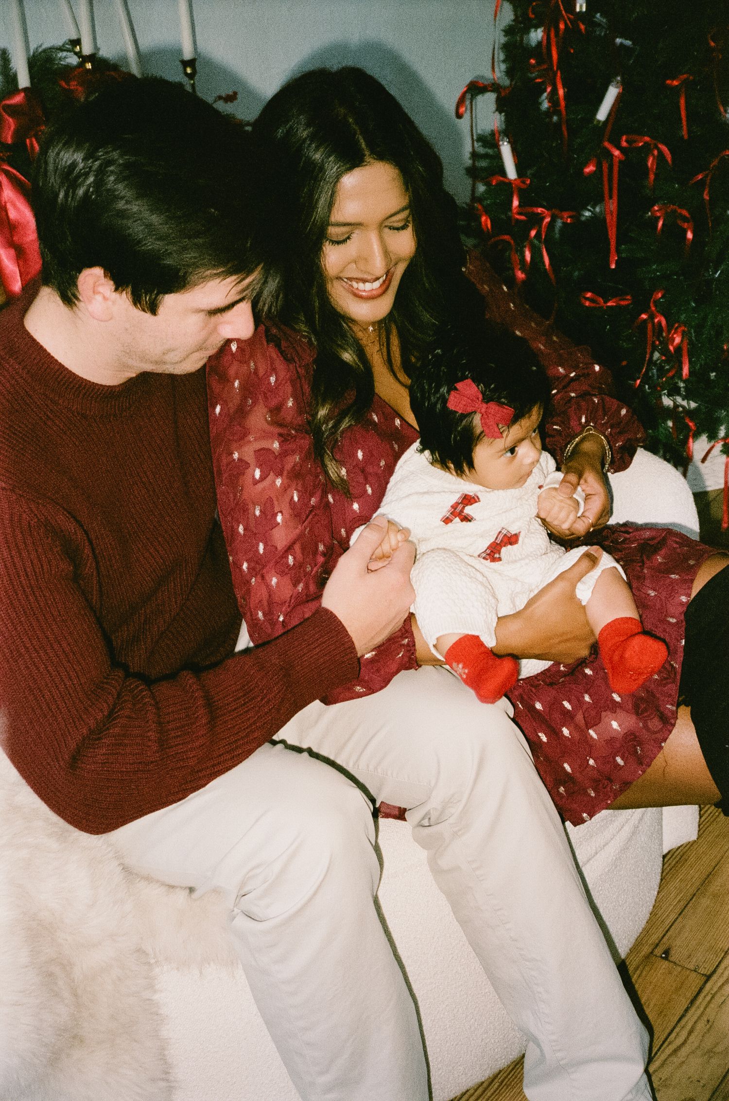 A sequence of candid party photos showing people laughing and embracing under red decorations at a festive gathering.