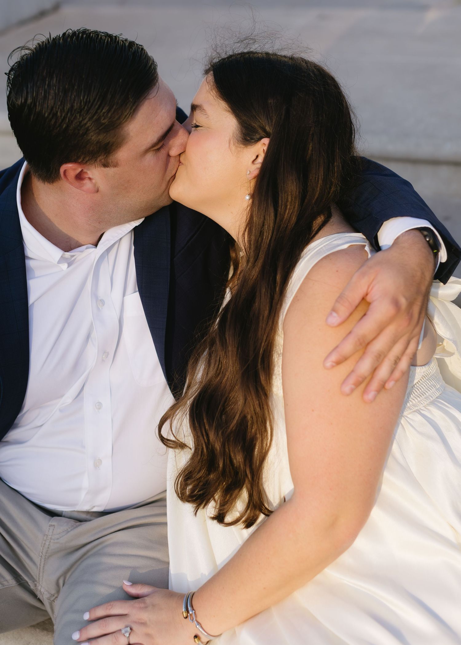 Series of intimate close-up shots showing couple embracing in white and navy formal attire.