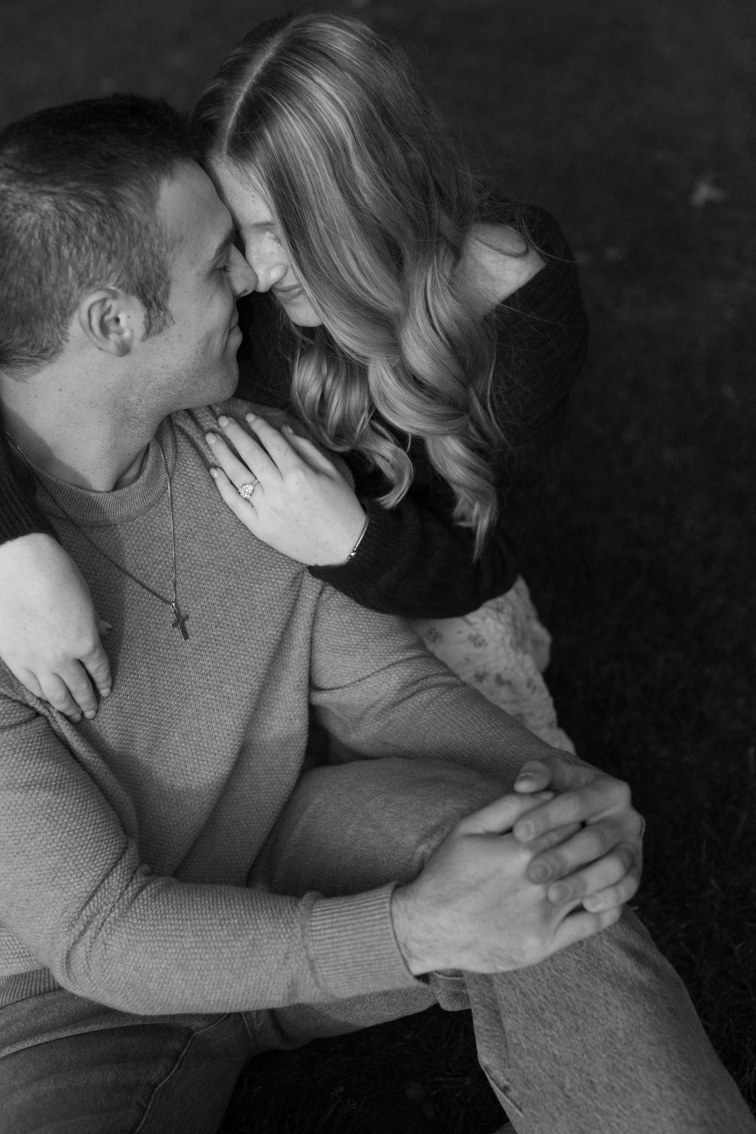 An intimate black and white portrait of a couple sharing a tender moment.