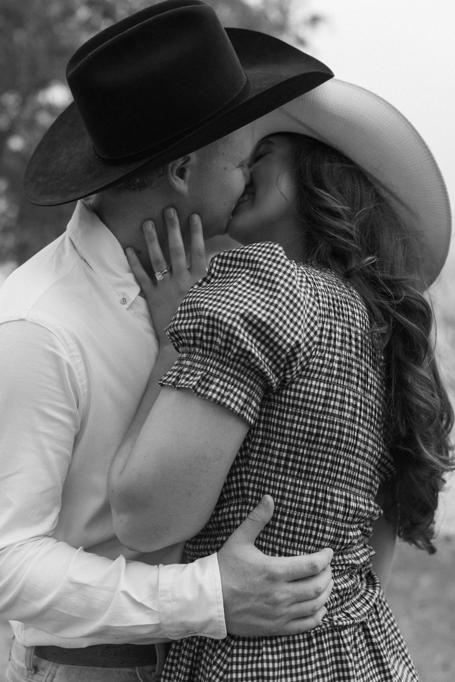 Romantic black and white photo series showing couple sharing intimate embraces while wearing cowboy hats.