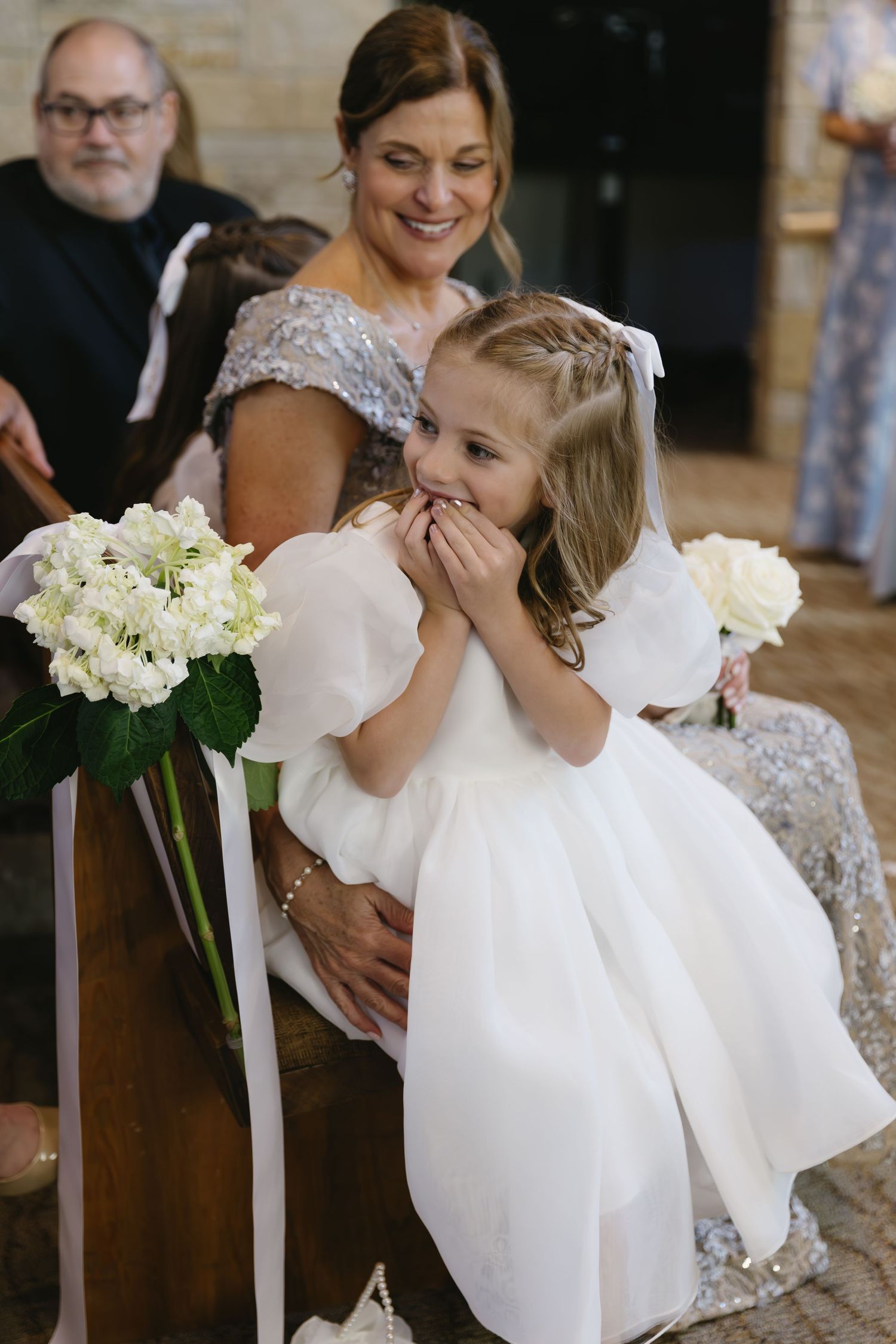White floral arrangements and decorative elements at an elegant wedding ceremony.