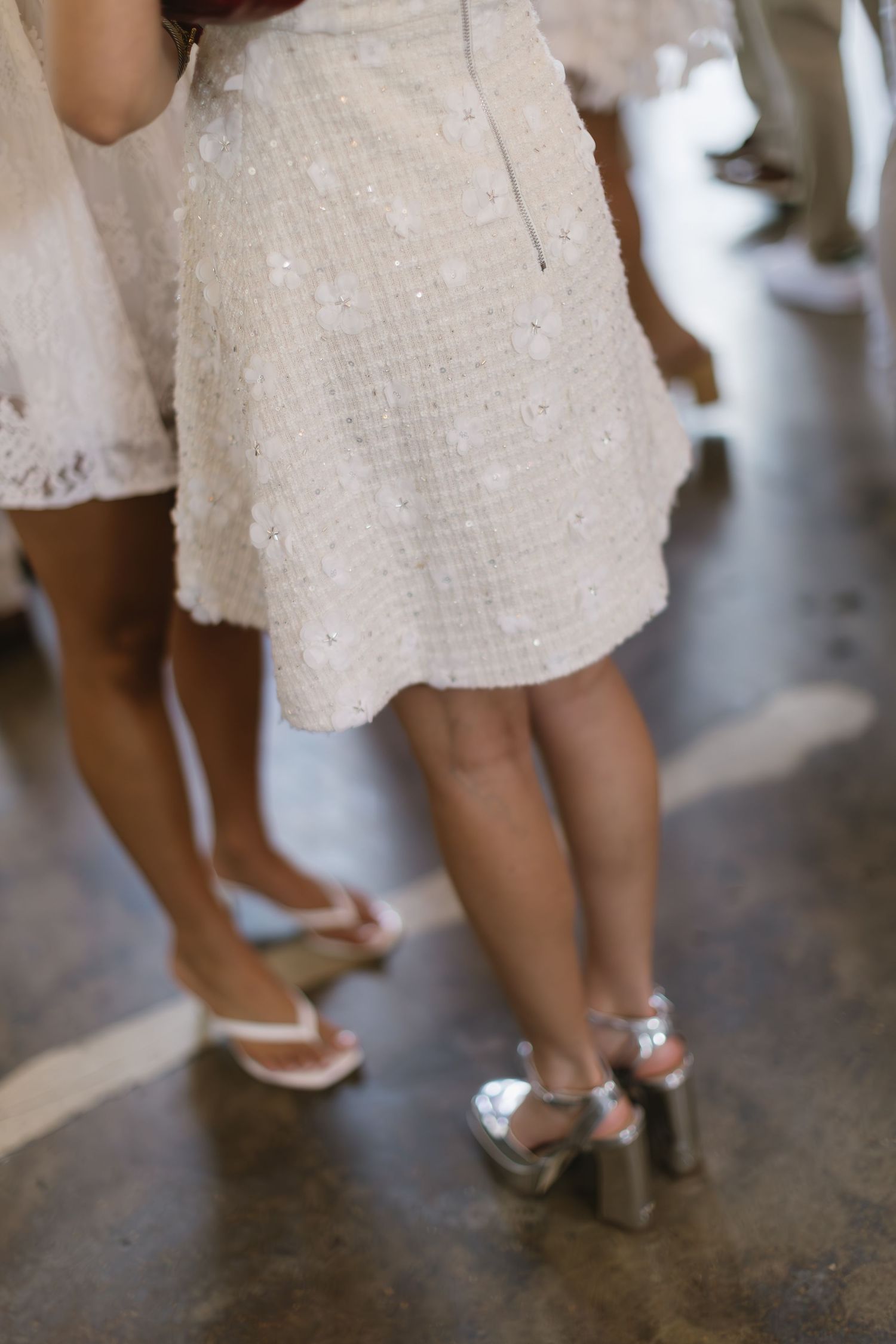 Close-up shots of a woman's feet in white shoes against a dark floor.