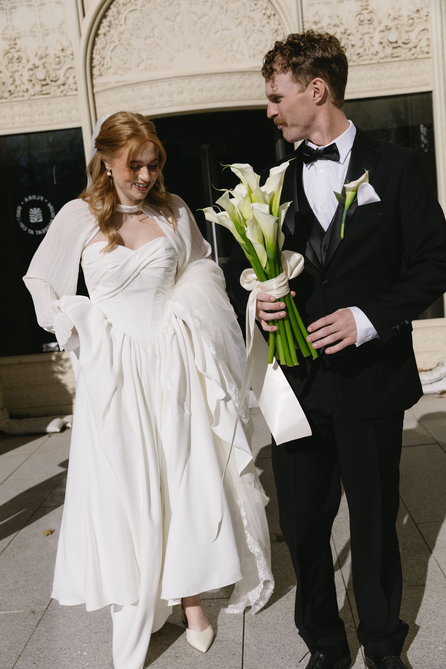 A couple in wedding attire poses together with white calla lily bouquet in a series of candid shots.