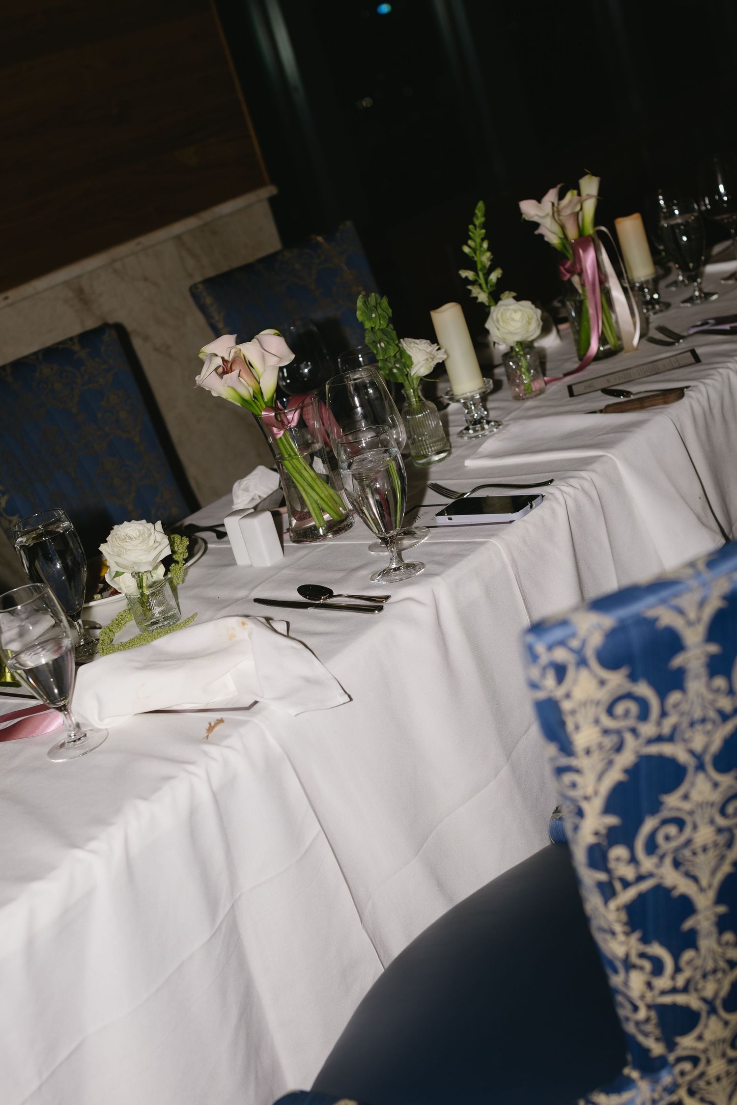 Elegant wedding reception table settings with white linens and floral centerpieces.