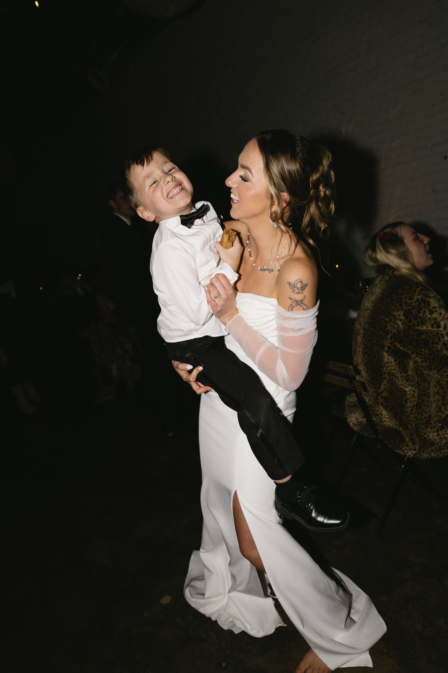 A joyful candid moment of dancing and laughter at a formal celebration.