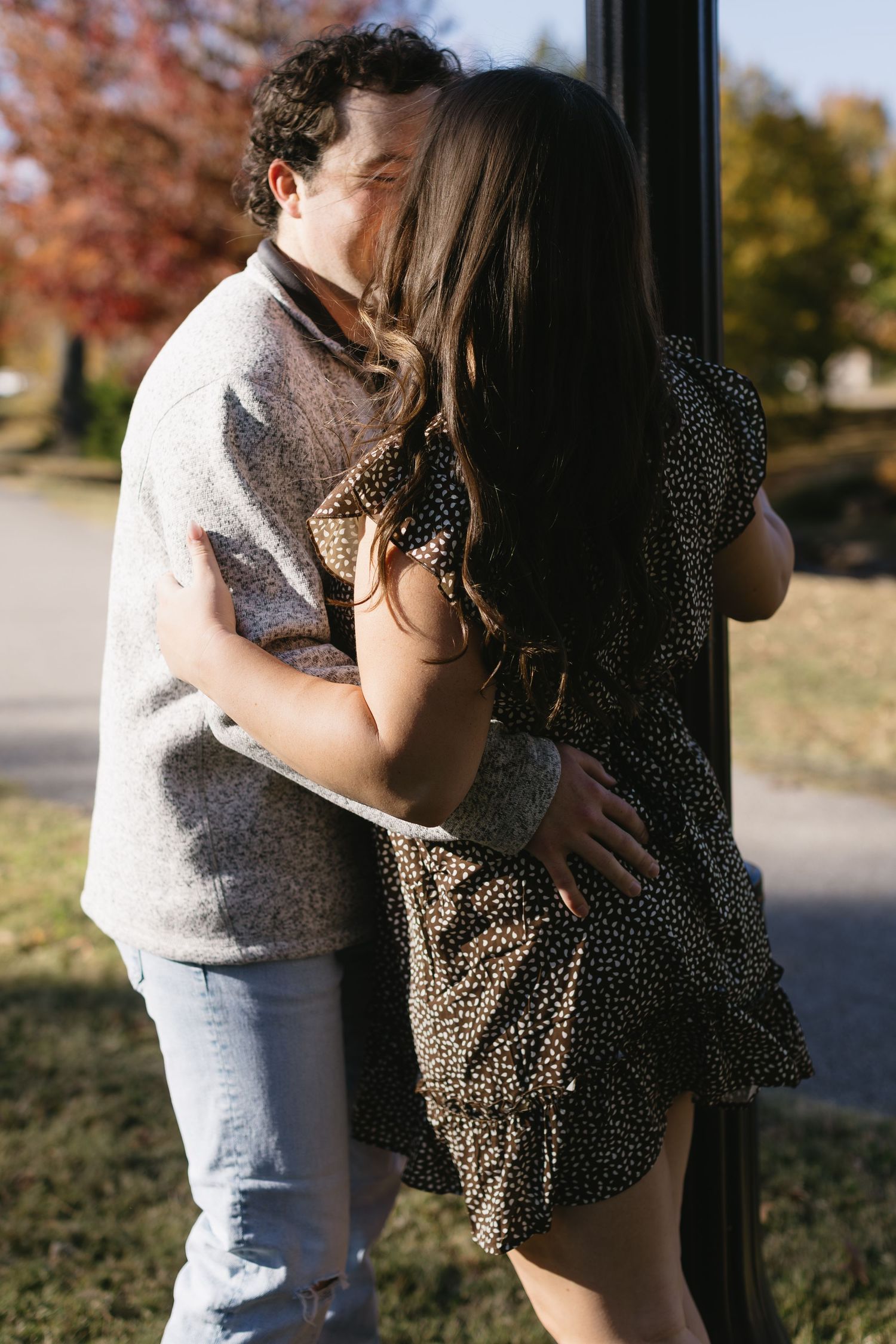 A romantic couple's portrait showing tender embrace in an outdoor autumn setting.