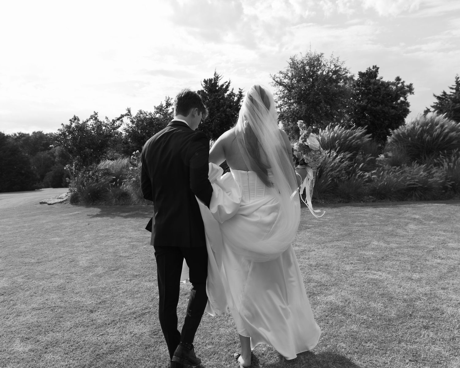 Romantic outdoor wedding photos with flowing white dress against natural landscape.