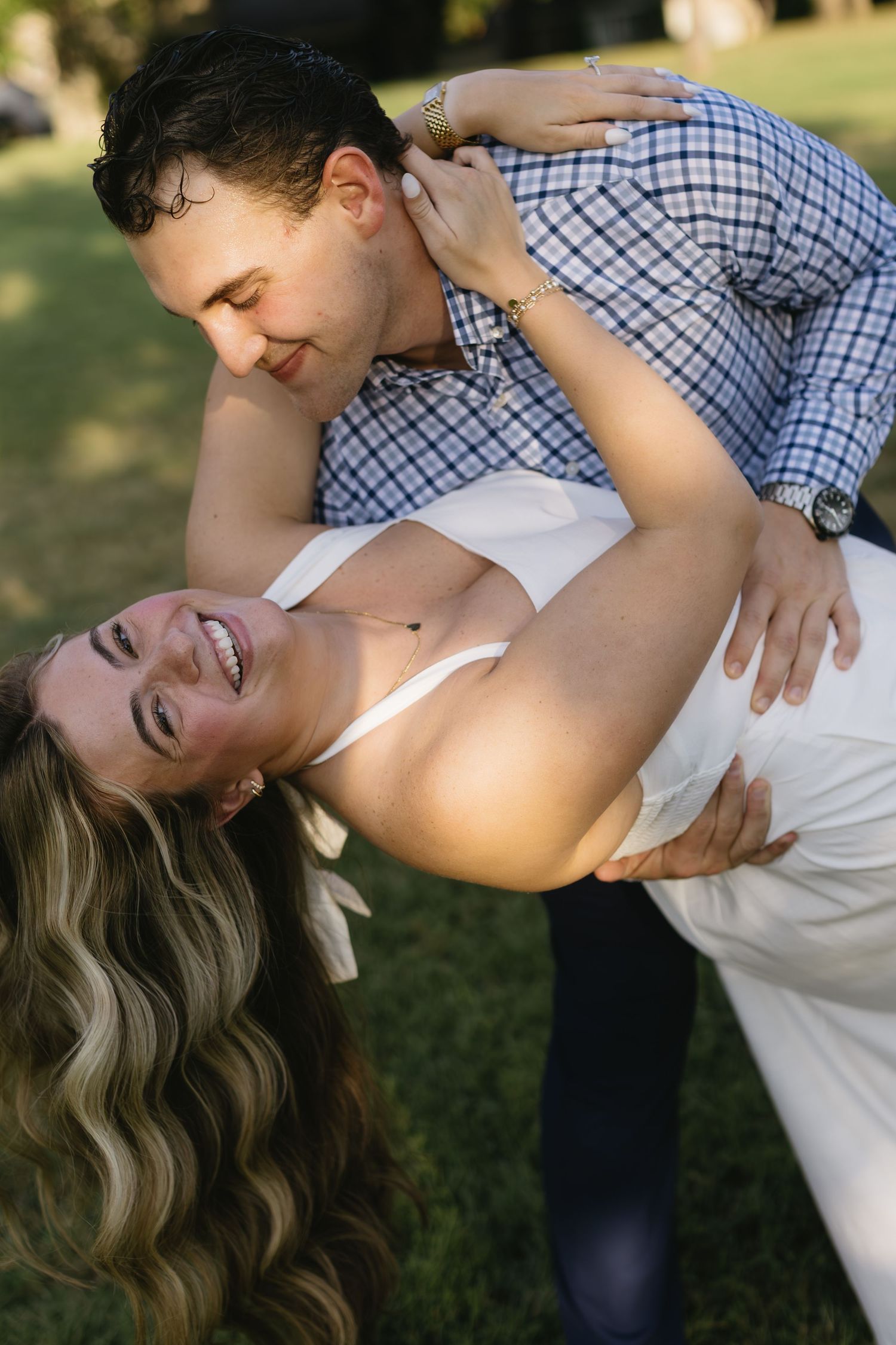 Romantic dip pose captured during outdoor couple's photoshoot at sunset.