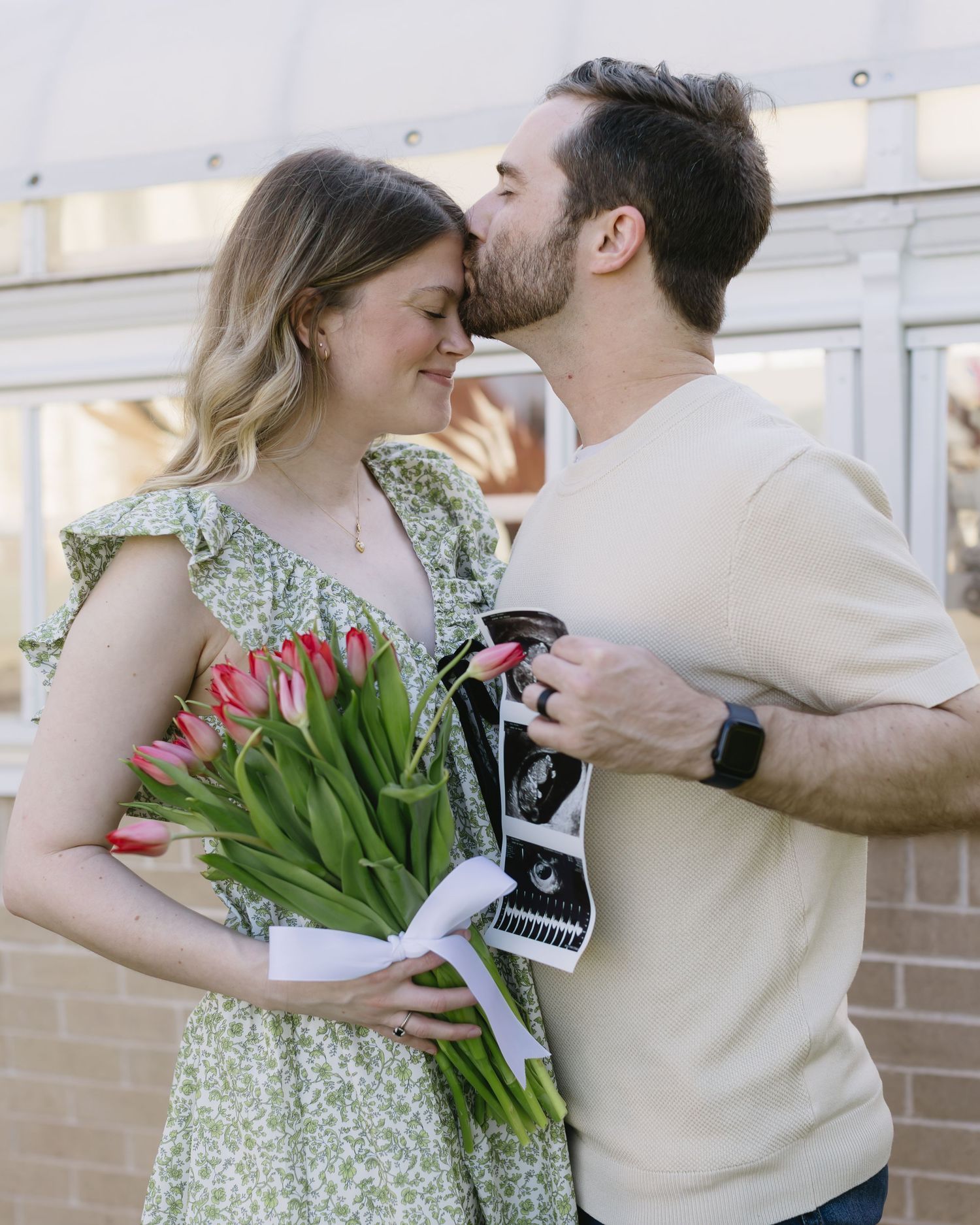 A romantic couple embraces on a porch with tulips and vintage polaroid camera style photos.