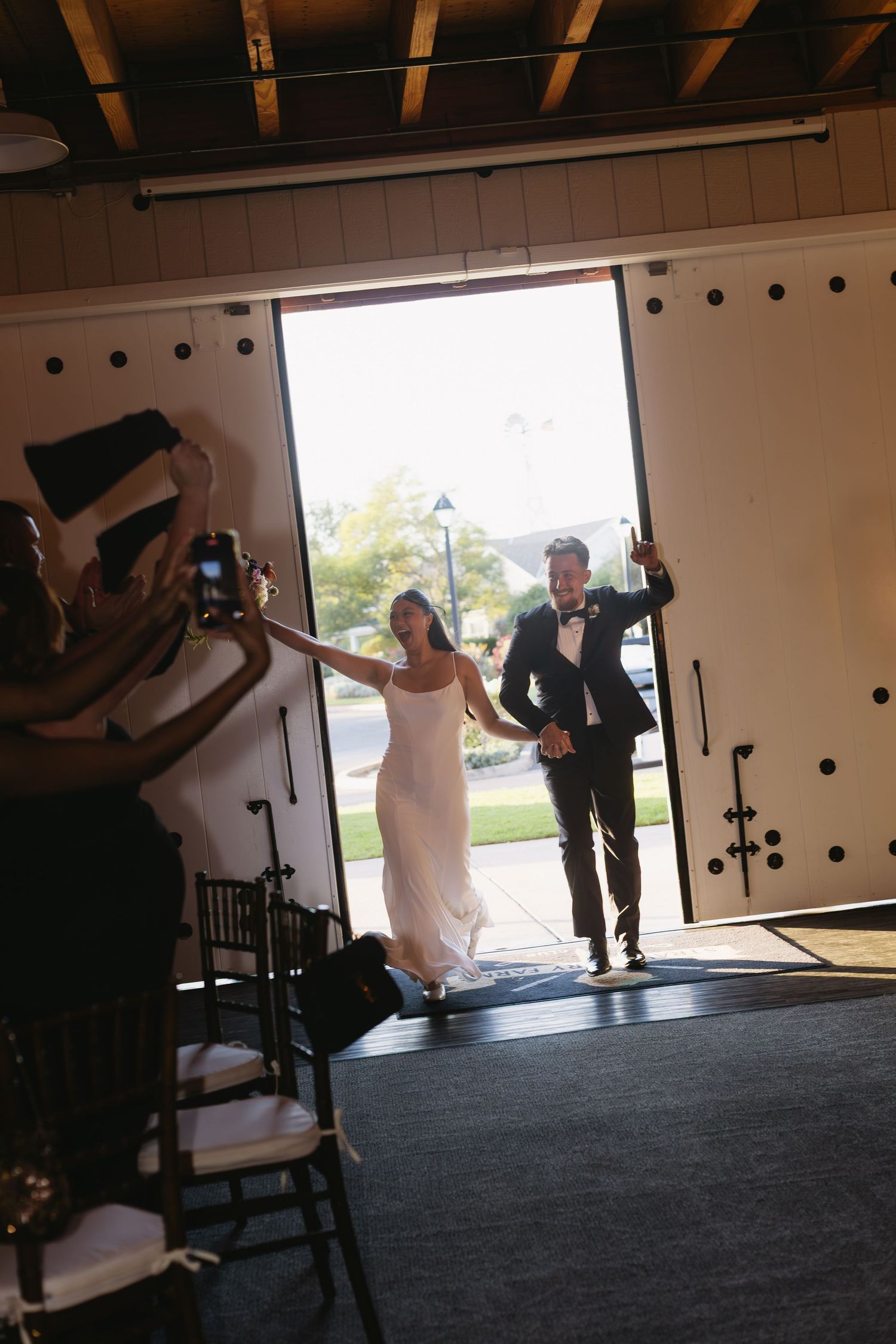 Wedding venue entrance with dramatic lighting and silhouetted figures in doorway.