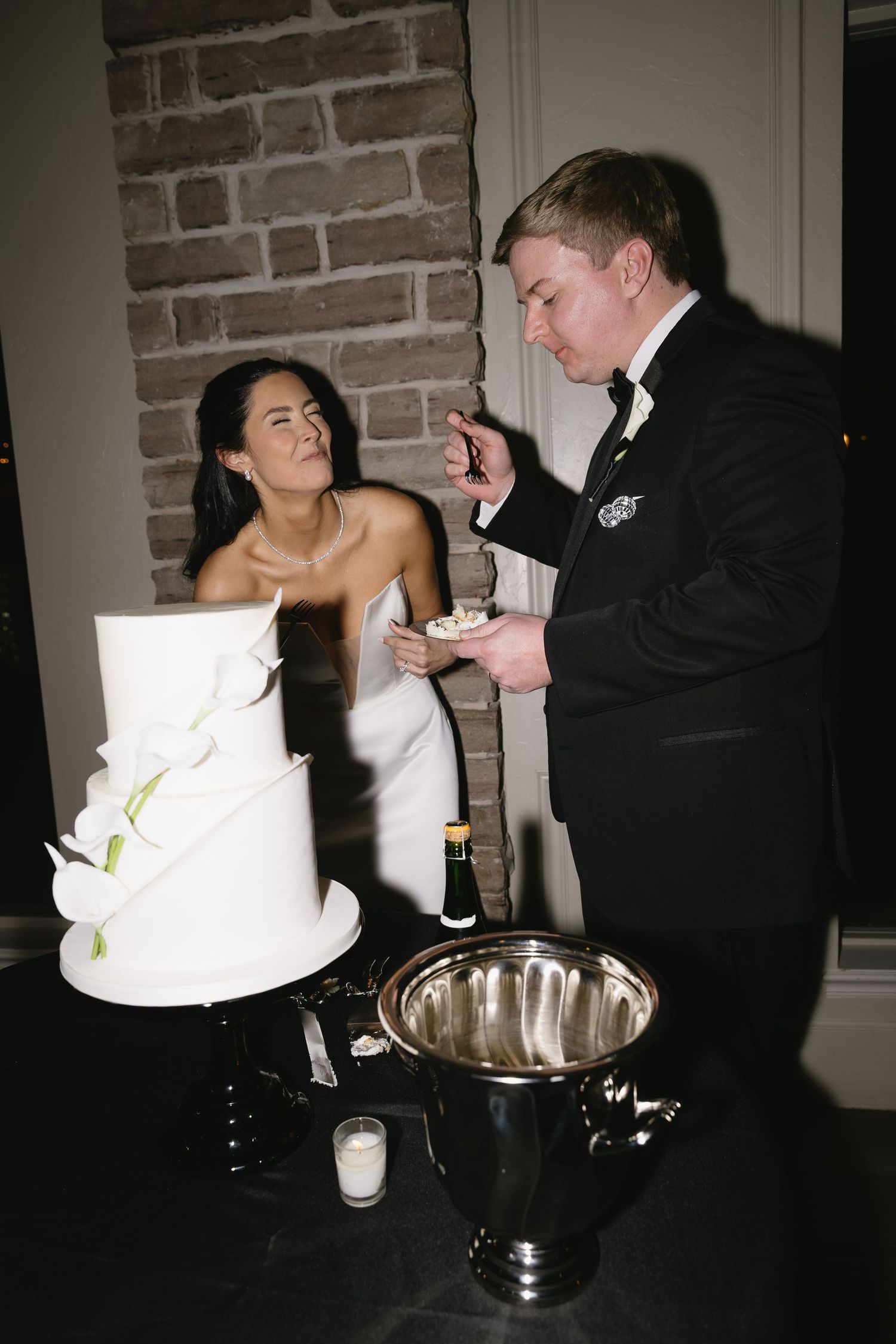 Wedding couple sharing a playful moment during their cake cutting ceremony.