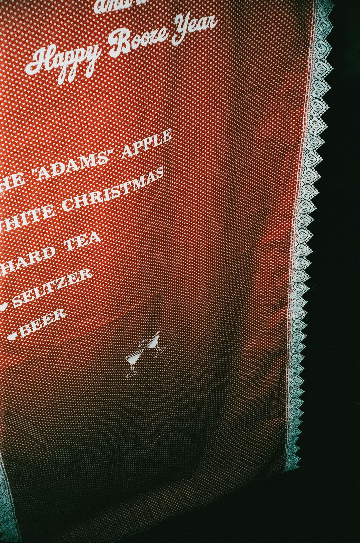 Red menu board with white text and lace trim displaying holiday drinks and beverages.