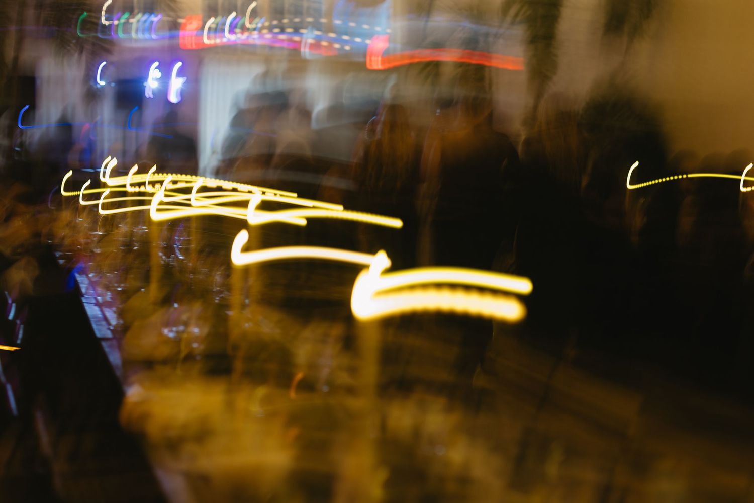 Abstract light trails creating artistic patterns in dark ambient lighting.
