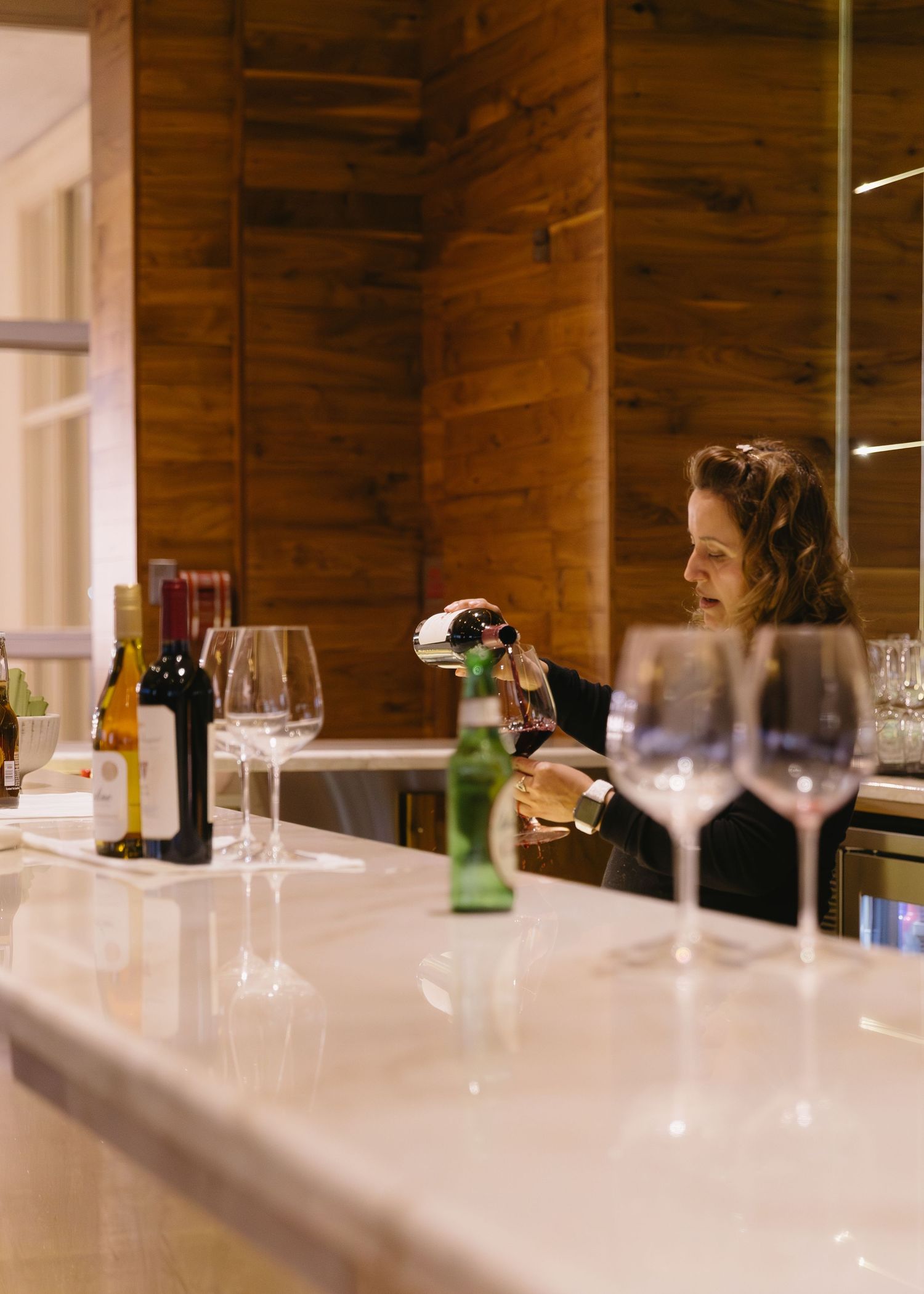 Modern white bar setup with wine glasses at an upscale wedding reception.