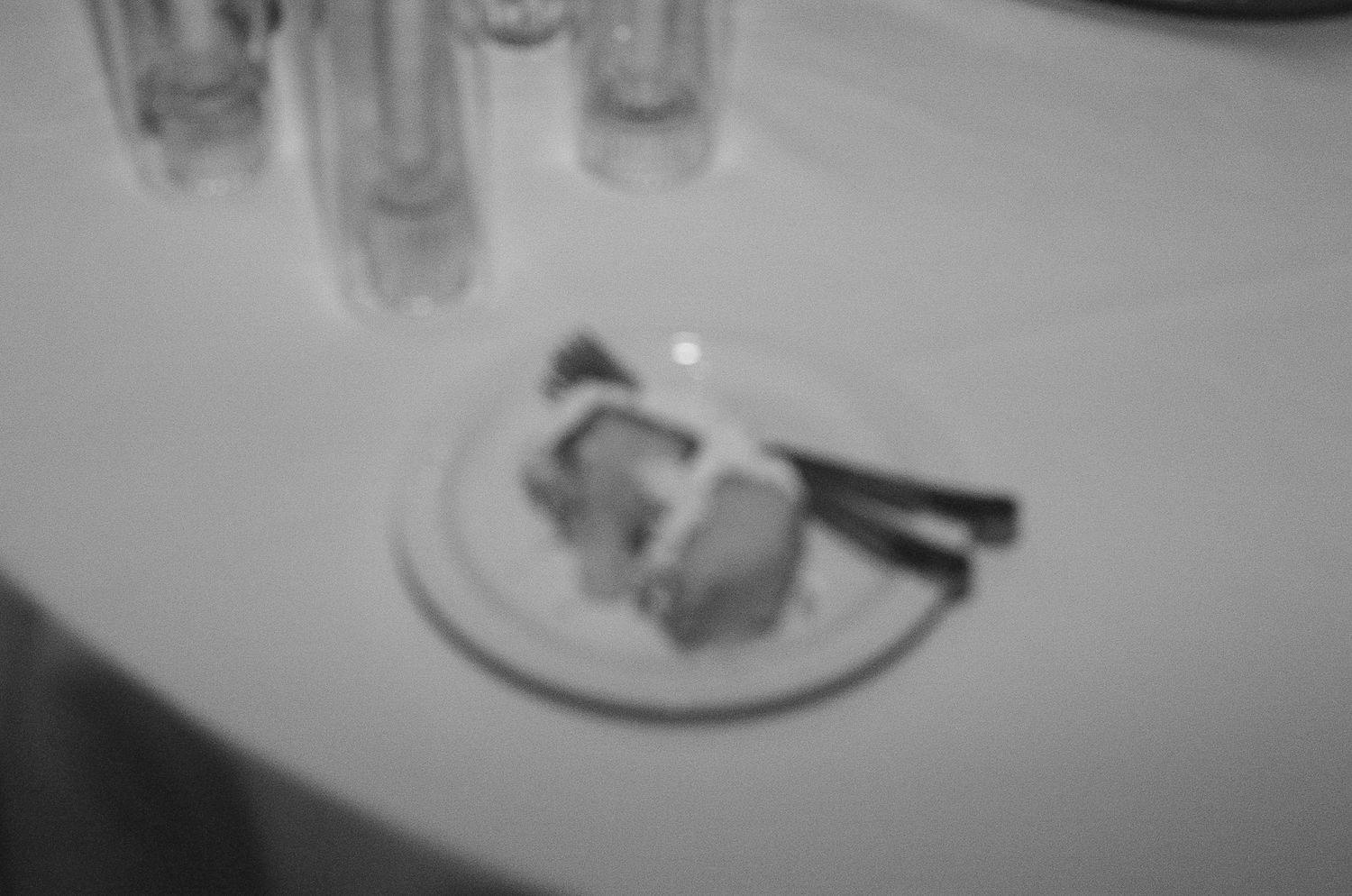 Blurred black and white detail shot of wedding reception table settings.