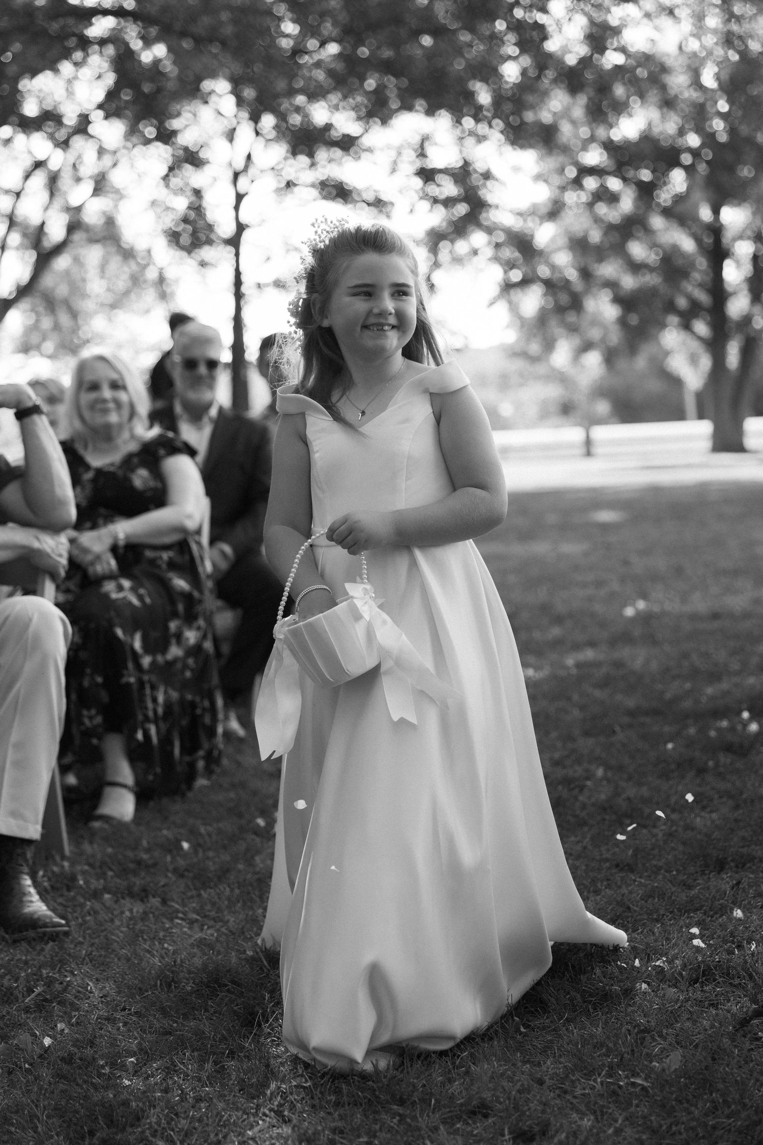 Wedding party celebrating outdoors with guests in black and white attire.