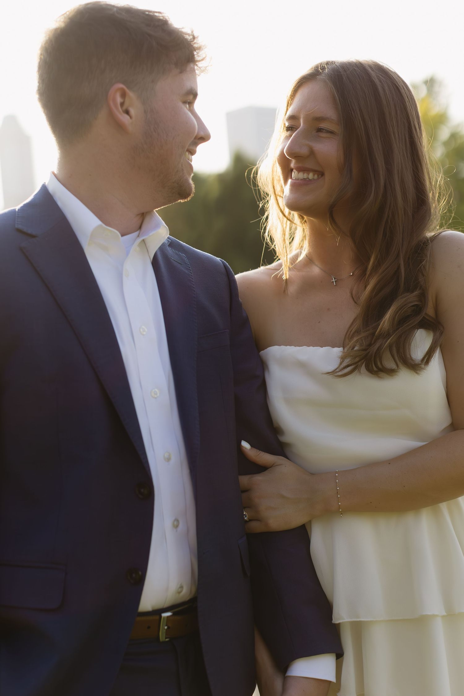 A tender moment between a couple dressed in formal attire captured in natural lighting.