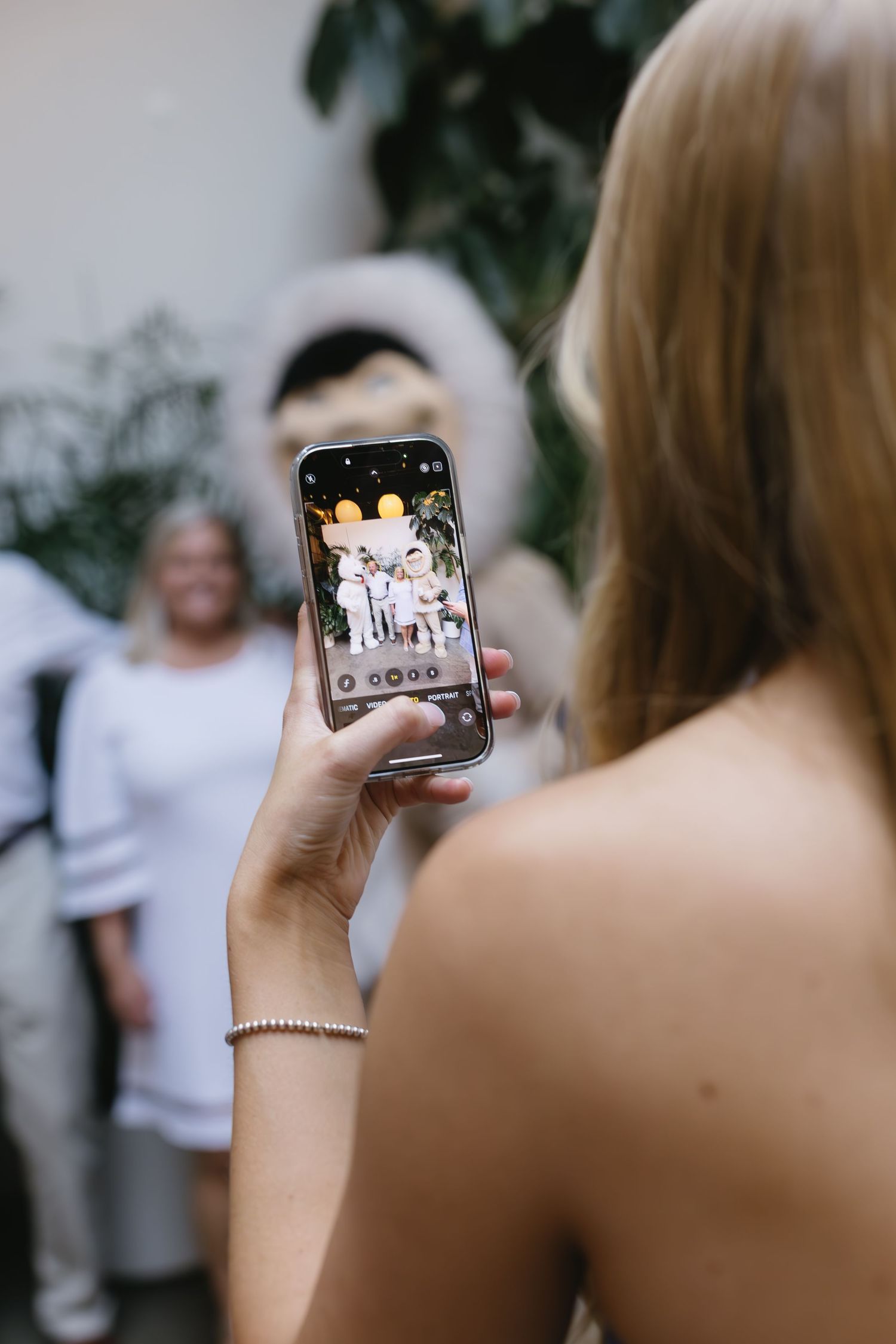 Someone takes photos on a smartphone during an evening event.