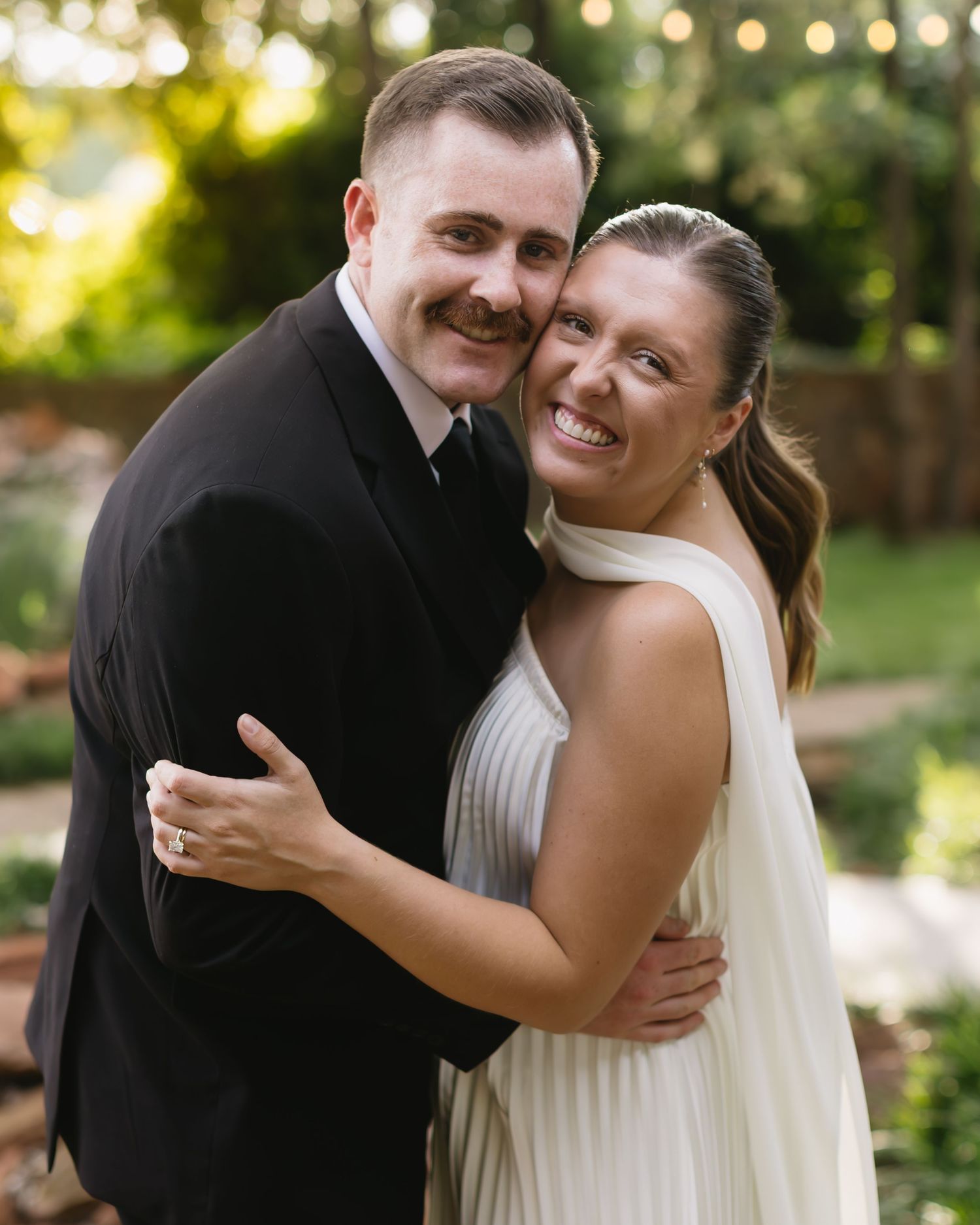 Joyful moment between couple dancing at outdoor wedding celebration.