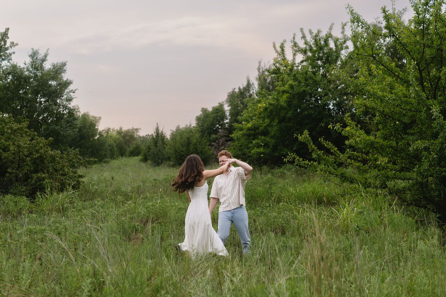 A series of romantic outdoor photos shows a couple sharing tender moments in a lush green meadow at sunset.