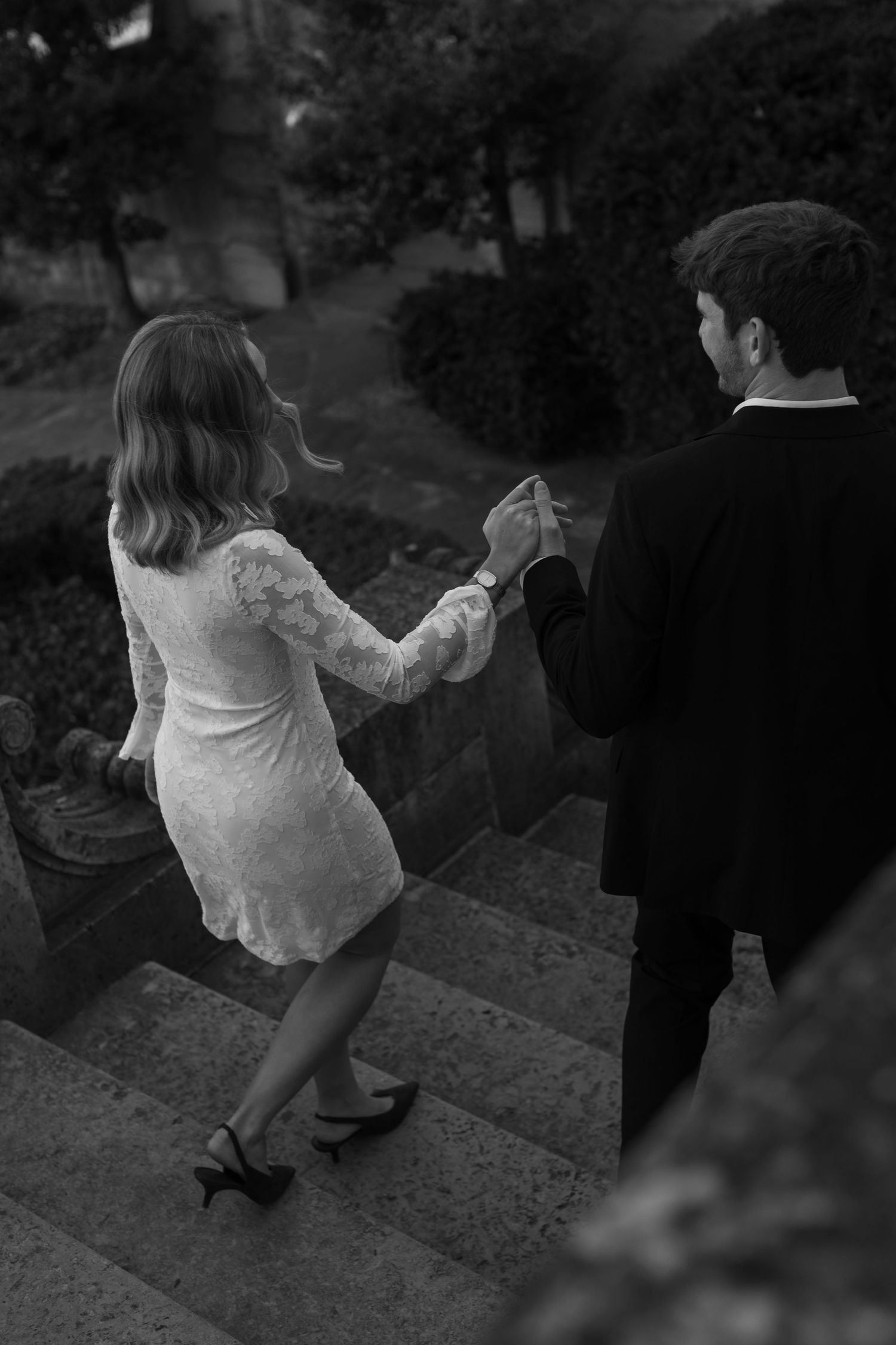 A black and white photo of a couple dancing on outdoor steps.