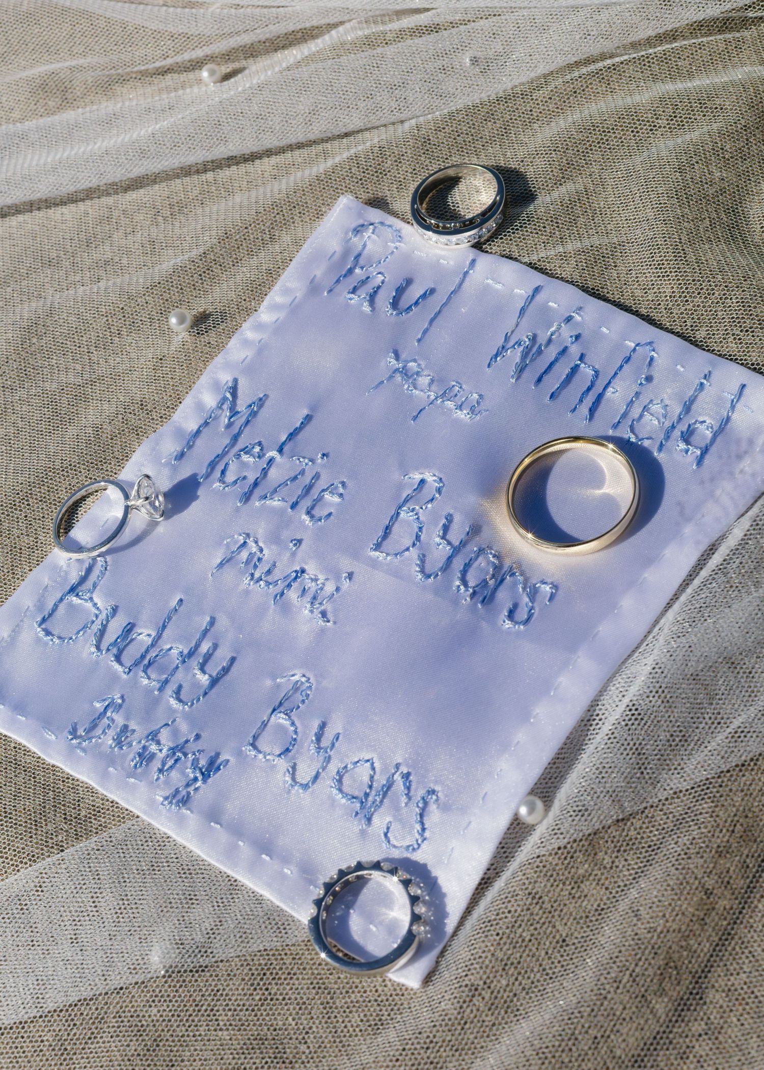Wedding rings arranged on a light blue paper with handwritten text.